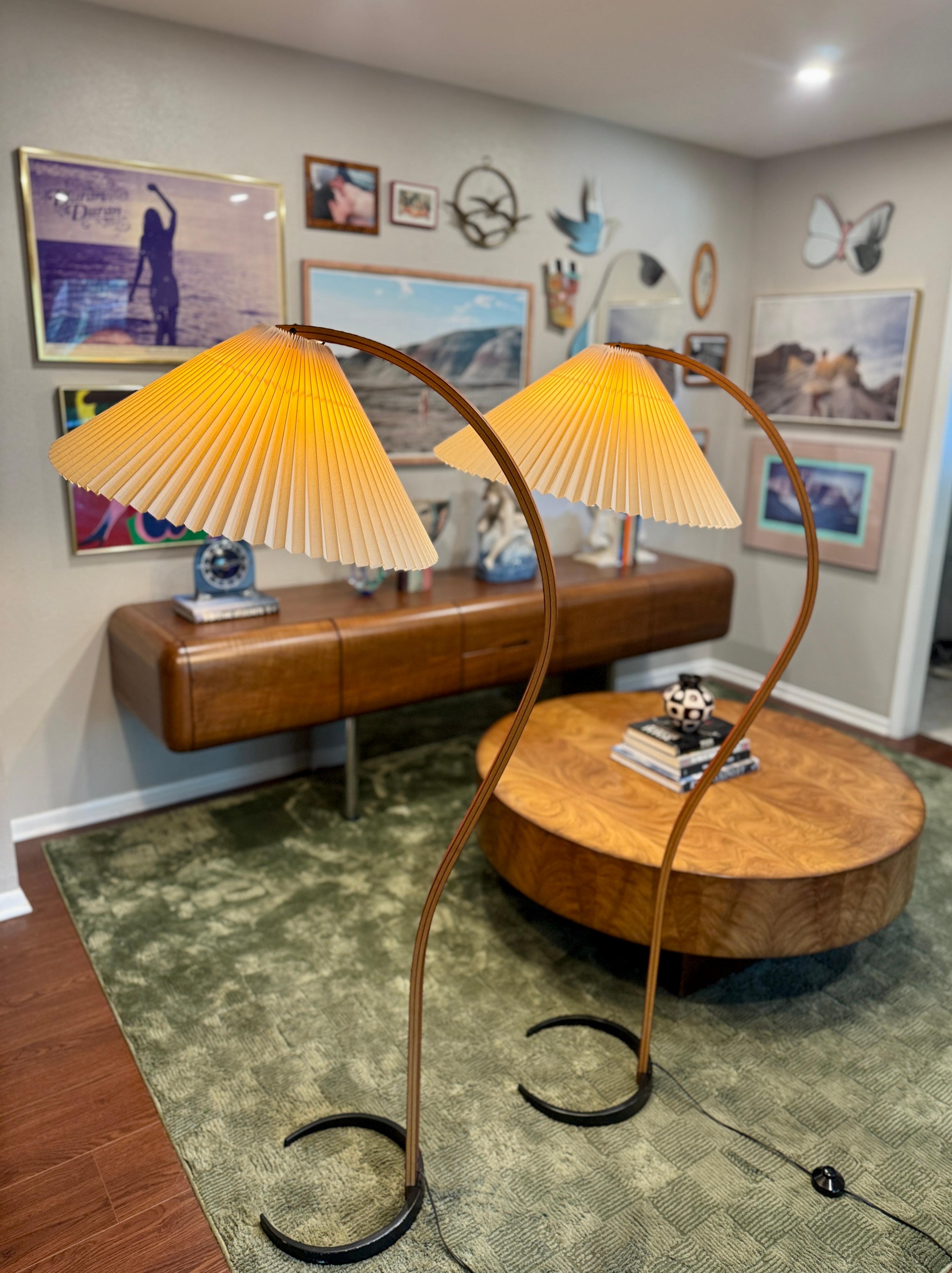 Una splendida coppia di lampade vintage in legno curvato Caprani, circa anni '70. Con base in ferro e struttura in legno curvato e paralumi originali plissettati, queste lampade da terra sono un reperto raro. Design originale al 100% di Mads