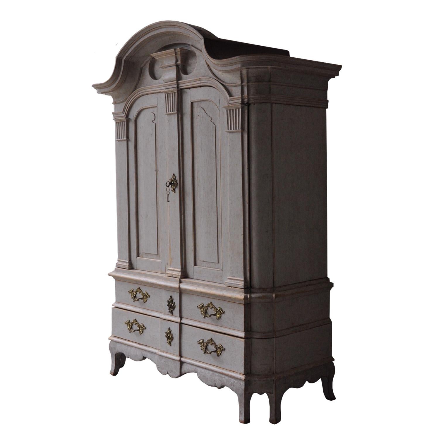 A stunning Rococo cabinet, simply one of the best cabinets we have sourced in sometime. This piece features a deep decorative carved pediment with a cartouche feature, a pair of carved double doors with Corinthian column sides opening to three