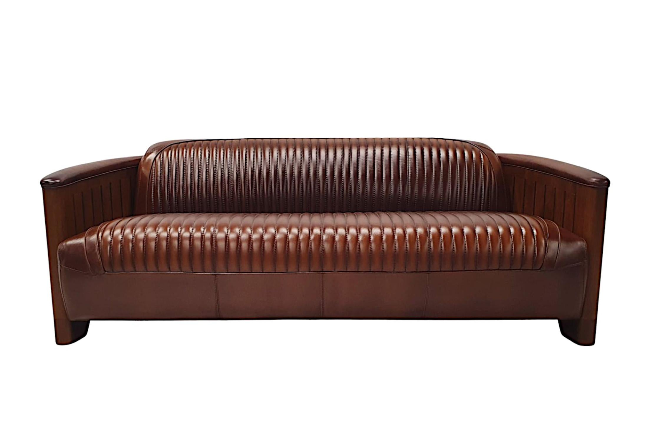 A stunning three seater leather and cherry wood framed contemporary sofa in the aviator style, of fabulous quality and with gorgeous patination and grain. Beautifully upholstered in elegant brown leather with innovative horizontal pipe stitch detail