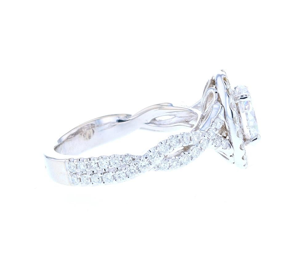 This beautiful custom engagement ring is crafted in platinum, and contains a stunning oval cut diamond surrounded by 72 round brilliant diamonds. With a gorgeous twisted split on the shank integrated into the ring design to create an undulating