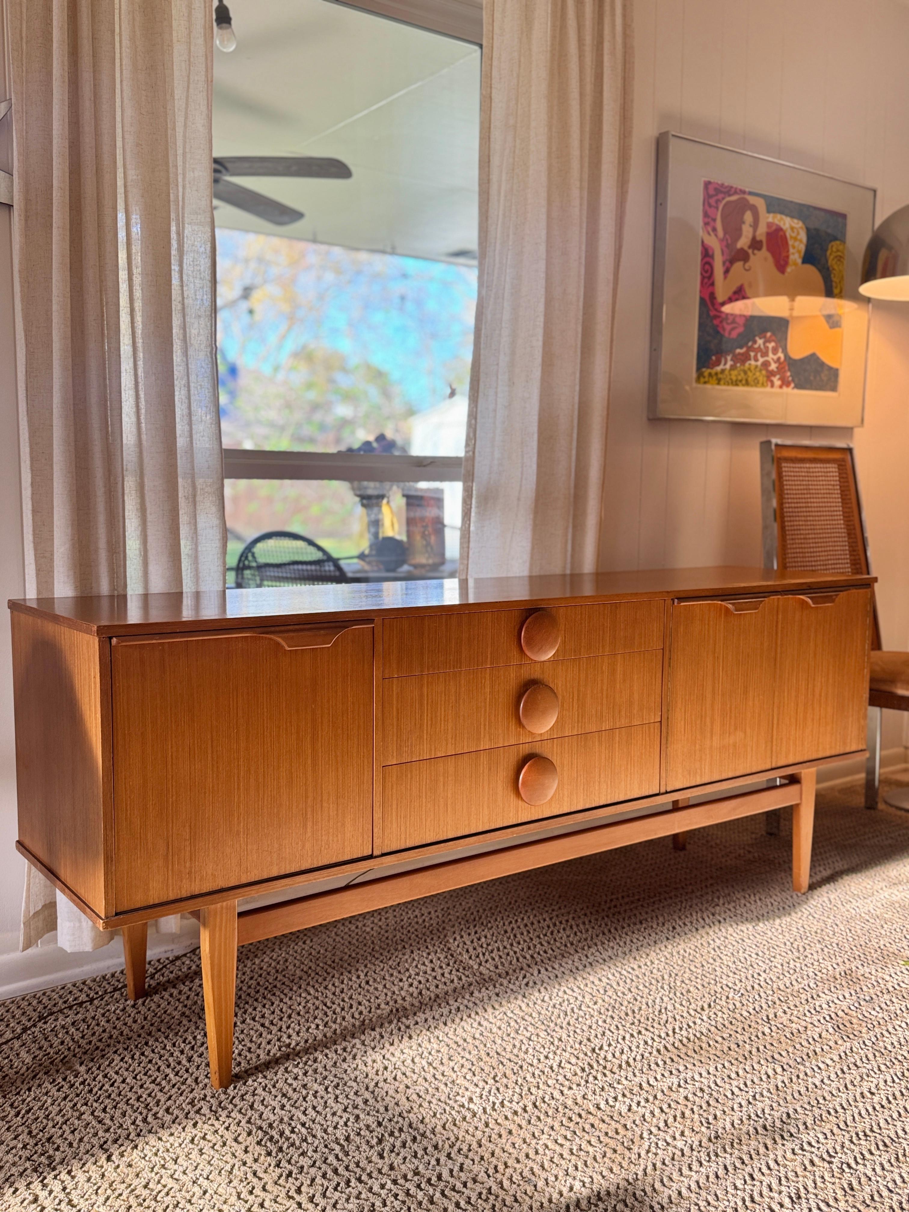 Un superbe buffet vintage en teck de Stonehill, vers les années 1960. Cette pièce exsude le charme du milieu du siècle avec son profil bas et épuré et sa fabrication élégante. Reposant sur un socle en teck massif, il affiche une présence raffinée