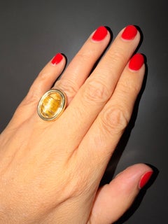 A stunning Yellow Gold Ring featuring a cabochon cut Rutilated Quartz.