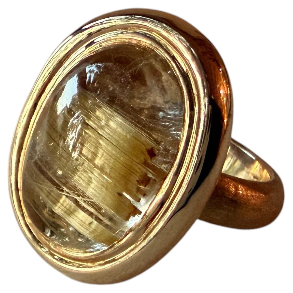 A stunning Yellow Gold Ring featuring a cabochon cut Rutilated Quartz. For Sale