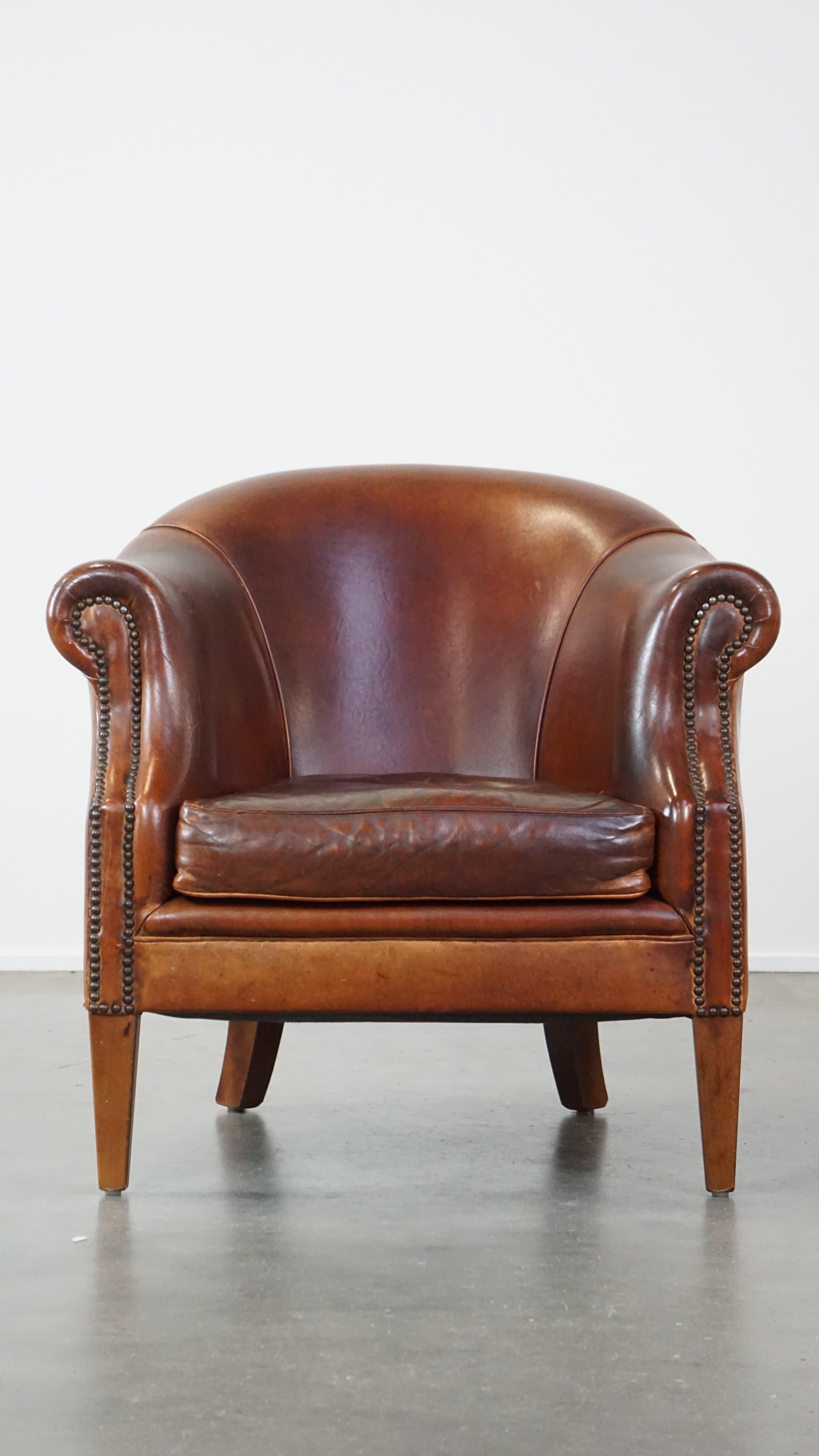 Ce fantastique fauteuil club en cuir de mouton affiche une belle allure luxueuse, notamment grâce à son design élégant. Il présente un design intemporel et une fabrication méticuleuse avec des détails de clous décoratifs. La chaise est équipée d'un