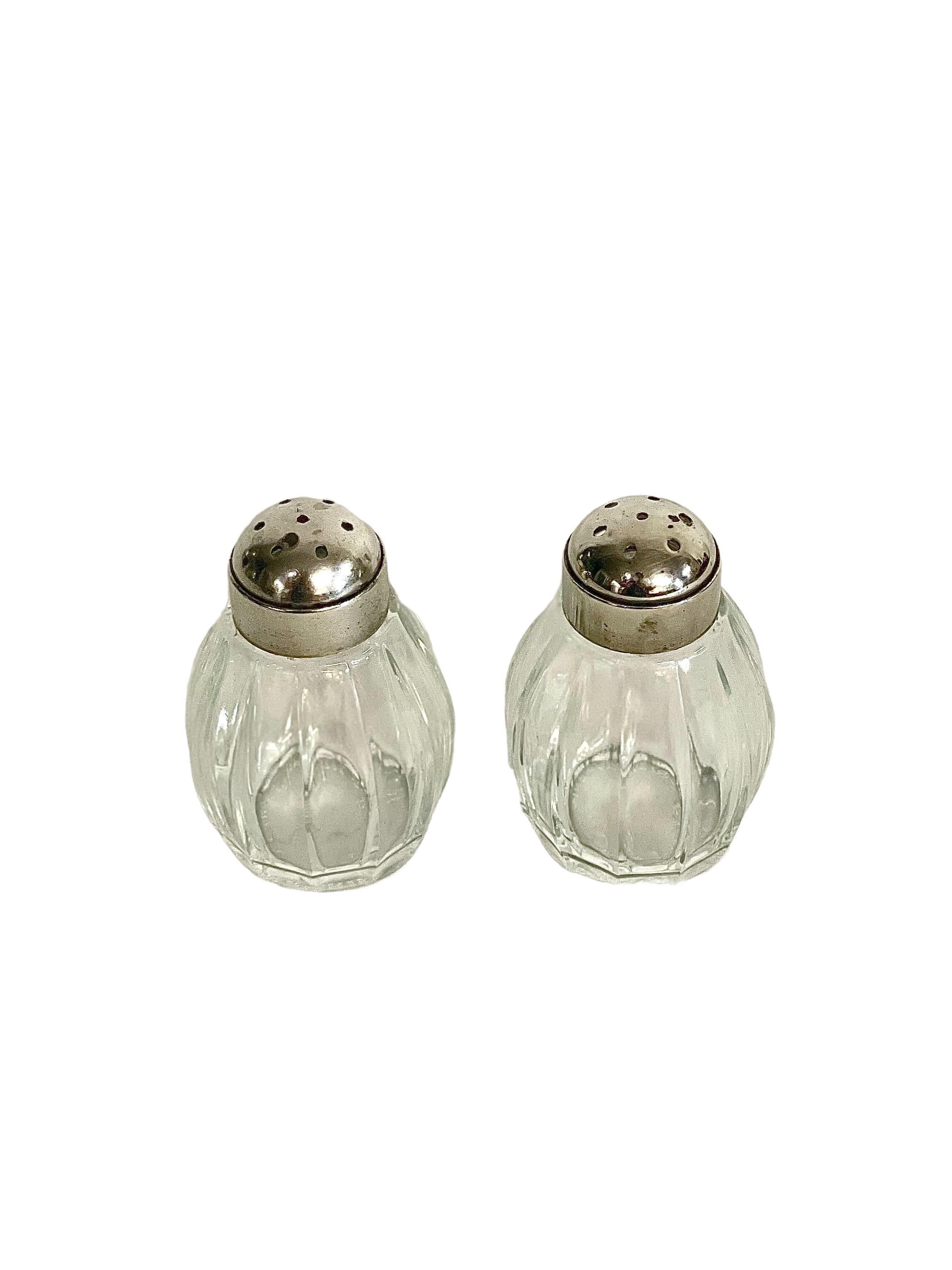 A stylish duo of Christofle Art Deco style salt and pepper shakers, with fluted crystal barrels and silver sterling screw-on lids. Dating from around the 1960s, each shaker unscrews for ease of refilling, and is stamped Christofle on the top and