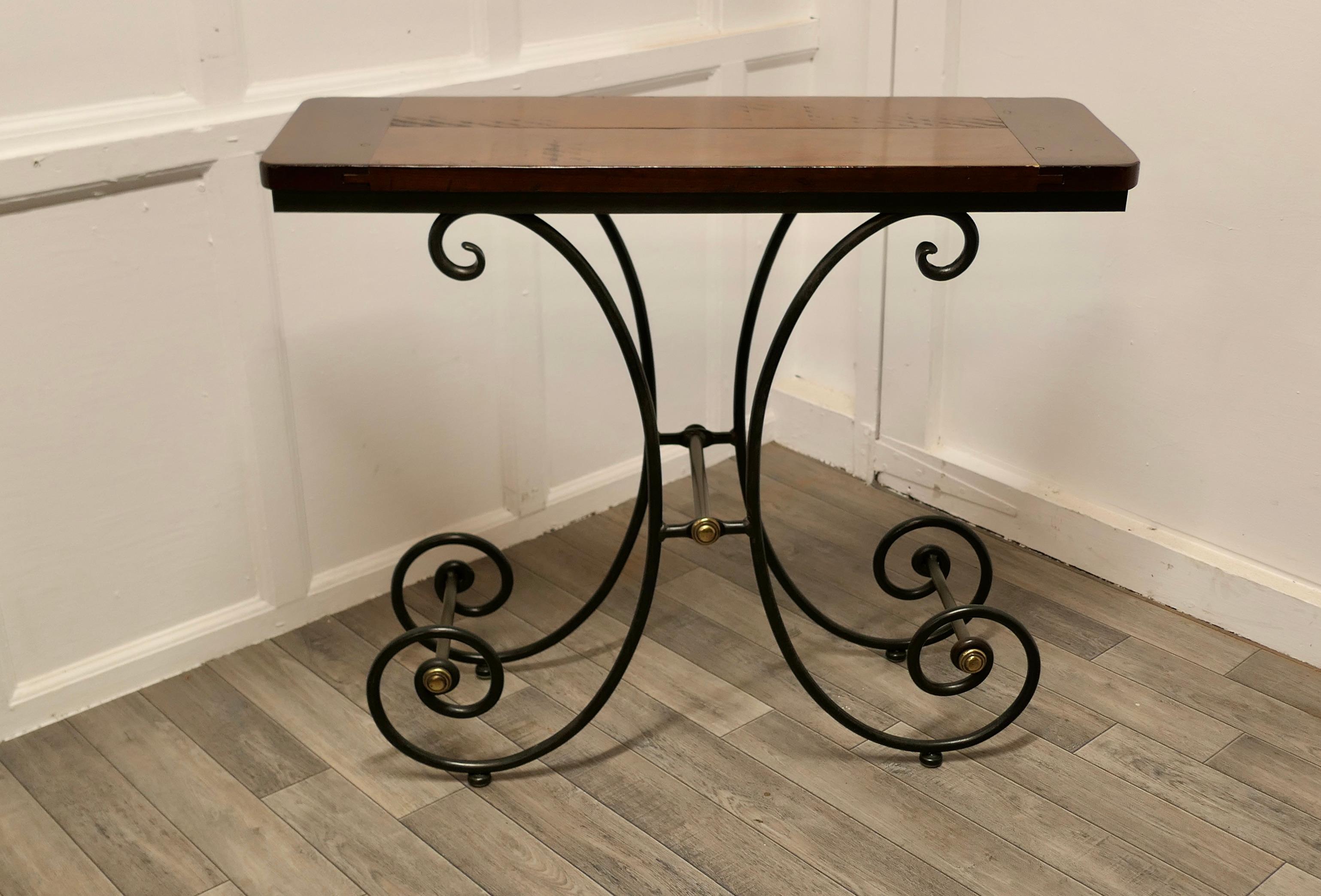 A stylish iron and elm console table.

 This is a lovely table has been designed in the style French bakers stand, it has the classic deeply curved legs we associate with those French Boulanger or Pâtisserie pieces. The base is forged in wrought