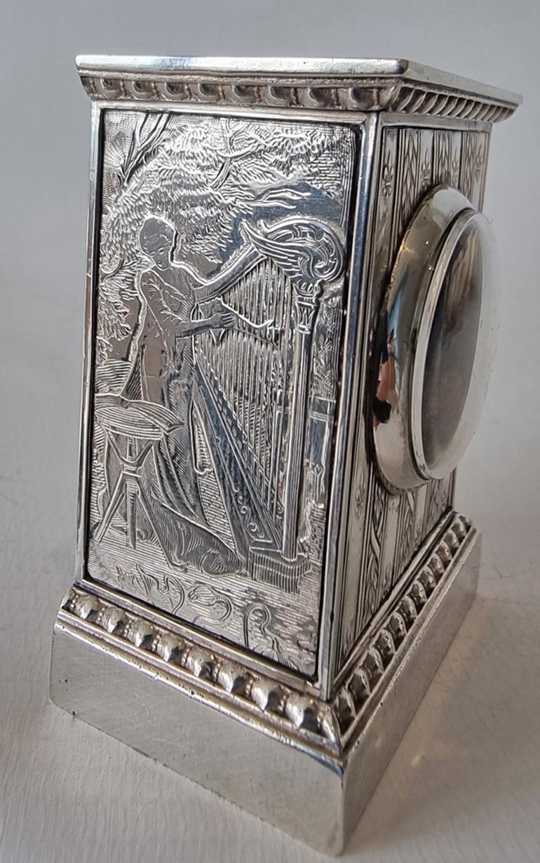 A very sub fine miniature silver carriage or boudoir clock with engraved scenes by Gubelin, with original leather case and key. This superb carriage clock with gorgeous engraved scenes to the sides, the skill here is really impressive for such a