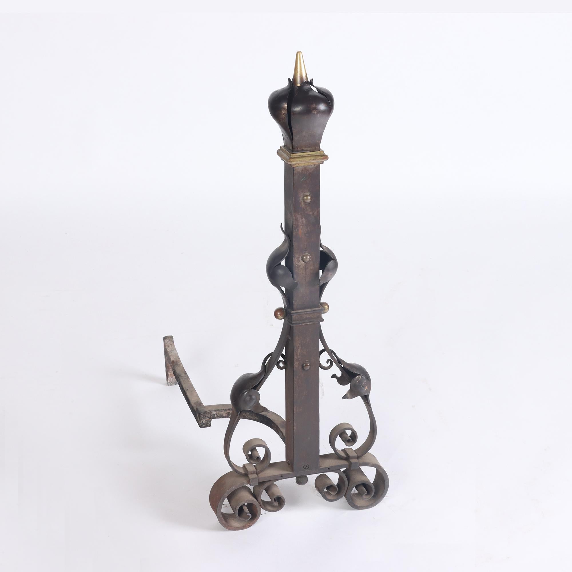 A substantial and monumental pair of nineteenth century French wrought iron and bronze andirons. Having stylized floral finials over bronze mounted column form post with stylized leaf decoration all raised on scrolling base.