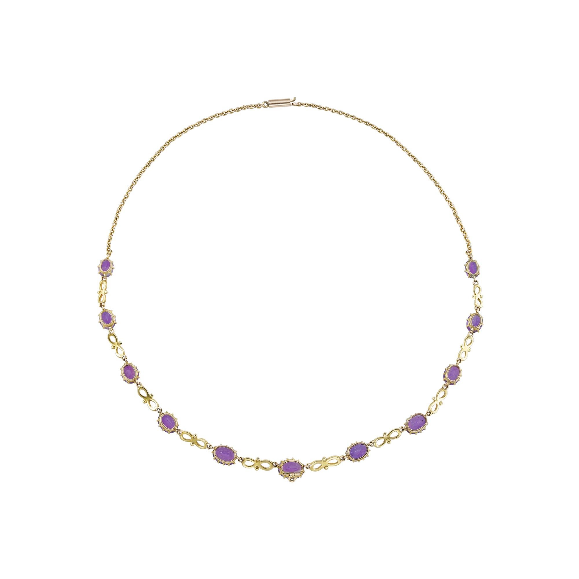 A suffragette amethyst and enamel necklace, consisting of eleven oval faceted amethysts graduating from the centre, connected with ten figure-of-eight white and green links, and suspended by a gold trace chain, the amethysts estimated to weigh 10.5