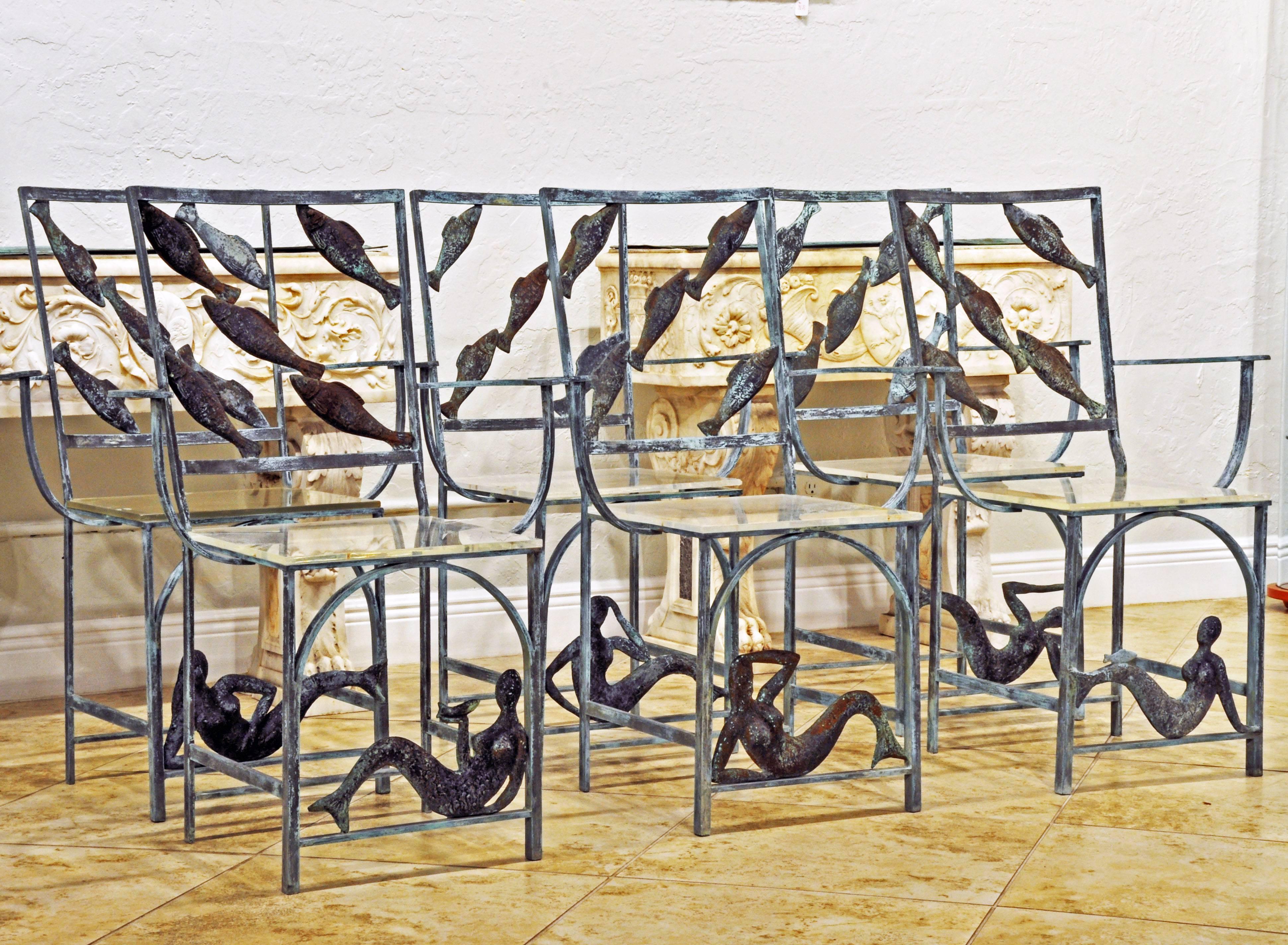 Made of solid weathered bronze and fitted with clear acrylic seats these chairs are different from anything we have ever seen. Their theme is the sea and they are adorned with swimming fish and gracious mermaids. Every chair slightly different when