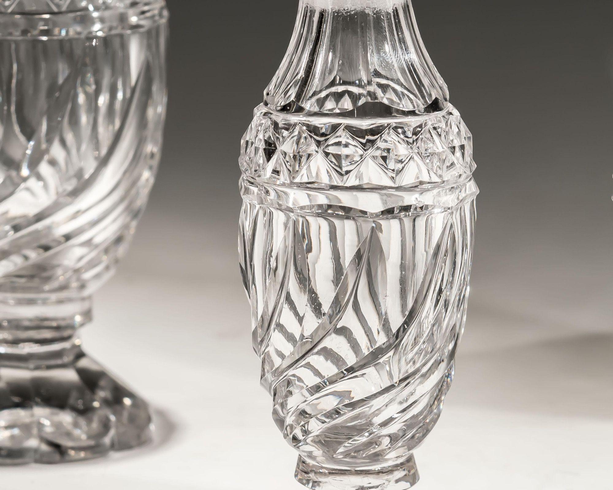 A suite of four Georgian cruet bottles with swirl cutting and a band of diamonds, with matching swirl cut stoppers. The suite consist of two large bottles and two smaller.

Small bottles
height: 16cm / 6 1/4