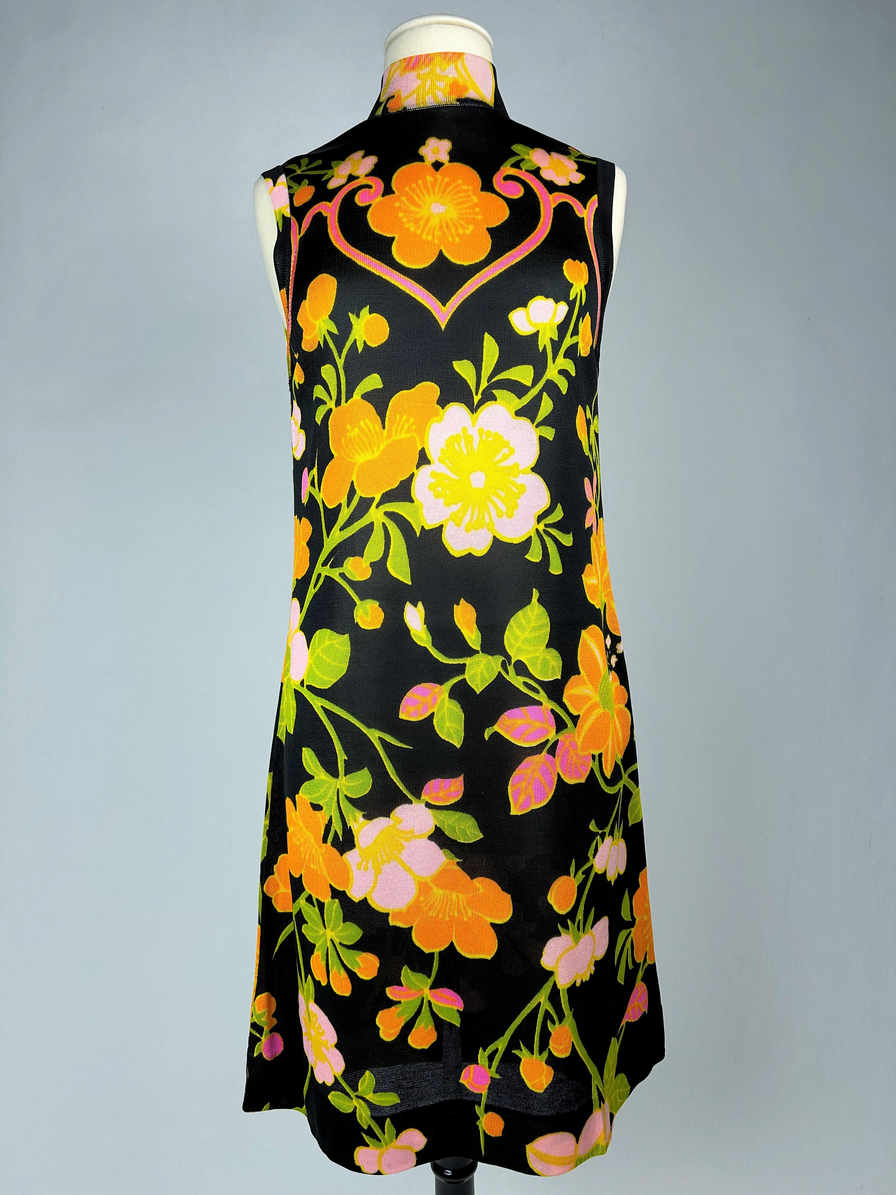 Circa 1968

France

A Printed silk knit mini-dress by Léonard Paris, dating from the late 1960s. Sleeveless sack dress style straight cut and Mao collar with small zip in the back. Black background print with large psychedelic flowers in shades of