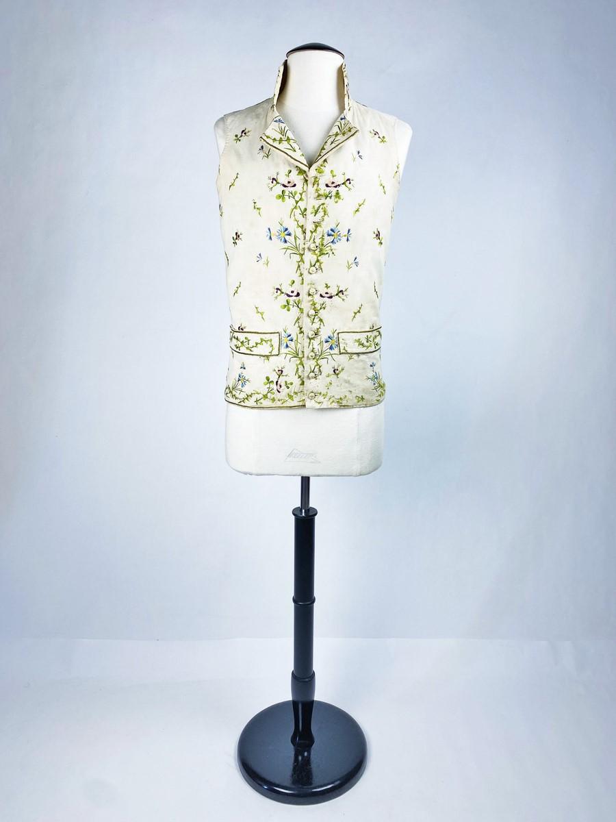 Circa 1795-1800
France
Charming summer waistcoat in cream twill wool embroidered with field flowers dating from the Directoire period. Square waistcoat with high collar and two flaps embroidered on both sides. Two flaps applied with real pockets