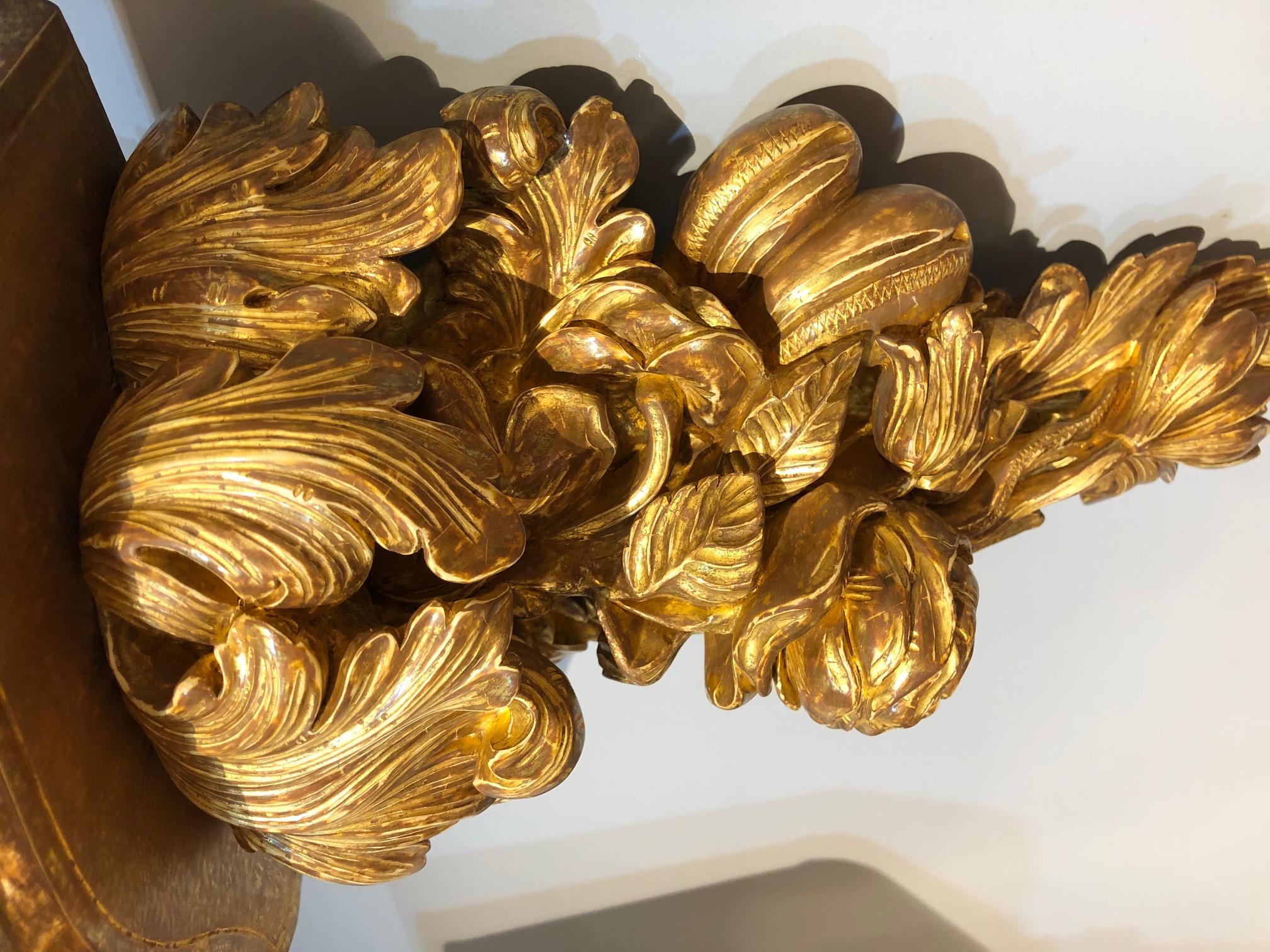 A  sumptuous pair of George III carved giltwood wall brackets, the lavishly carved supports having highly detailed and delightful carving of rosa centifolia, the Rose of Provence beneath, beside a hanging bunch of plump grapes, and also ripe plums,