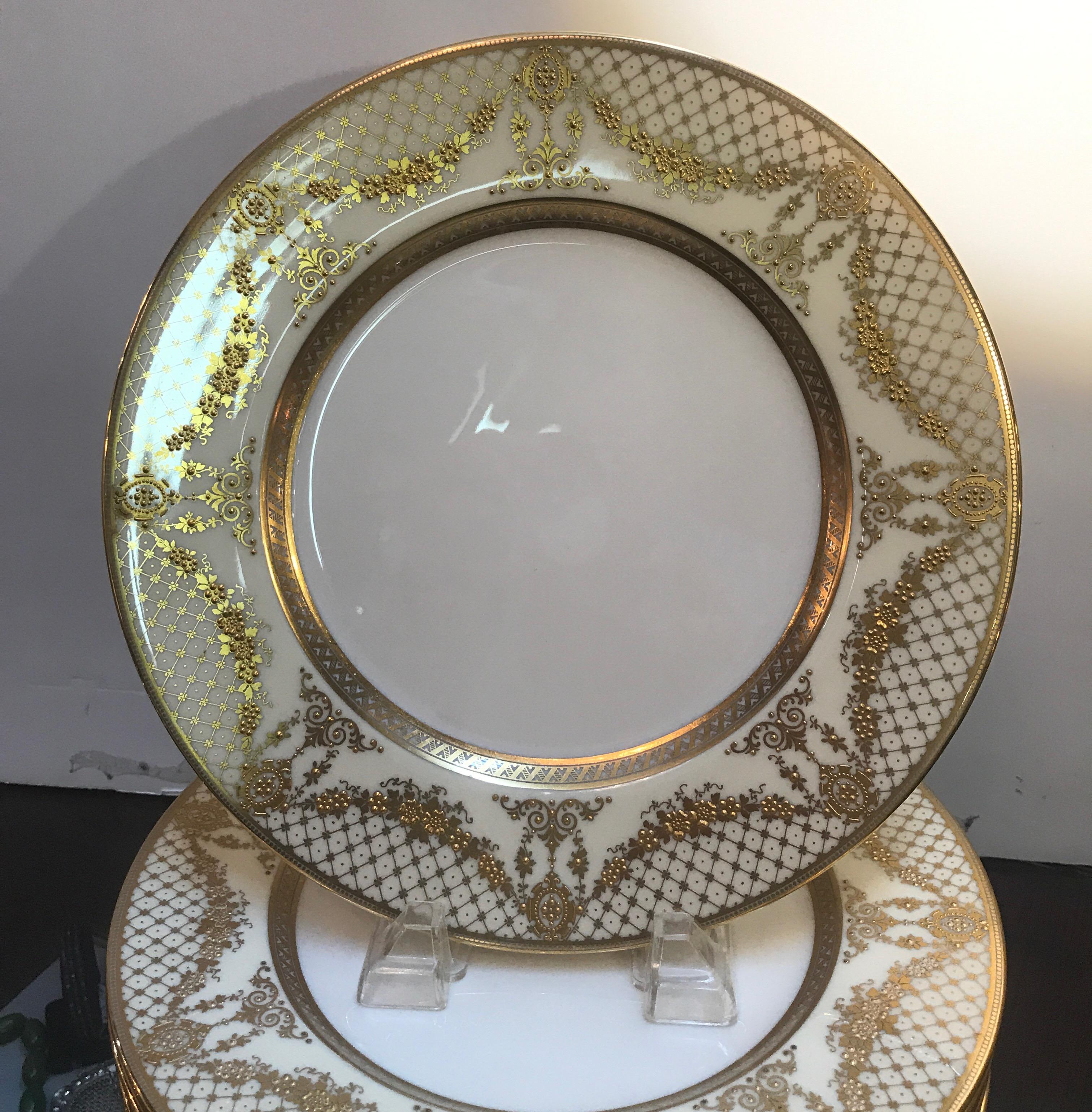 Elegant and graceful gilt service dinner plates with stunning gold encrusted border. The set was a custom pattern and in a lavish gold with slightly off white background. These plates will compliment almost any formal pattern in any color. The back