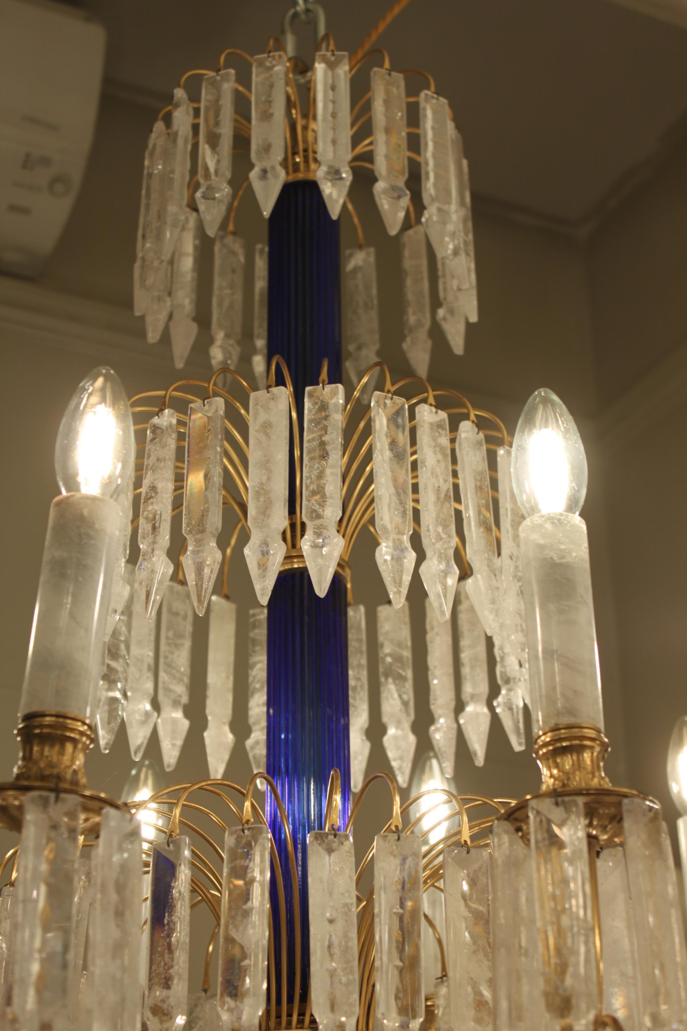 A beautiful Baltic style chandelier with cobolt blue corrugated crystal stem rising to an upper crown festooned with rock crystal myrzahs. A secondary broader lower ring of the same, beneath which is a wider ring of 8 outswept arms each terminating
