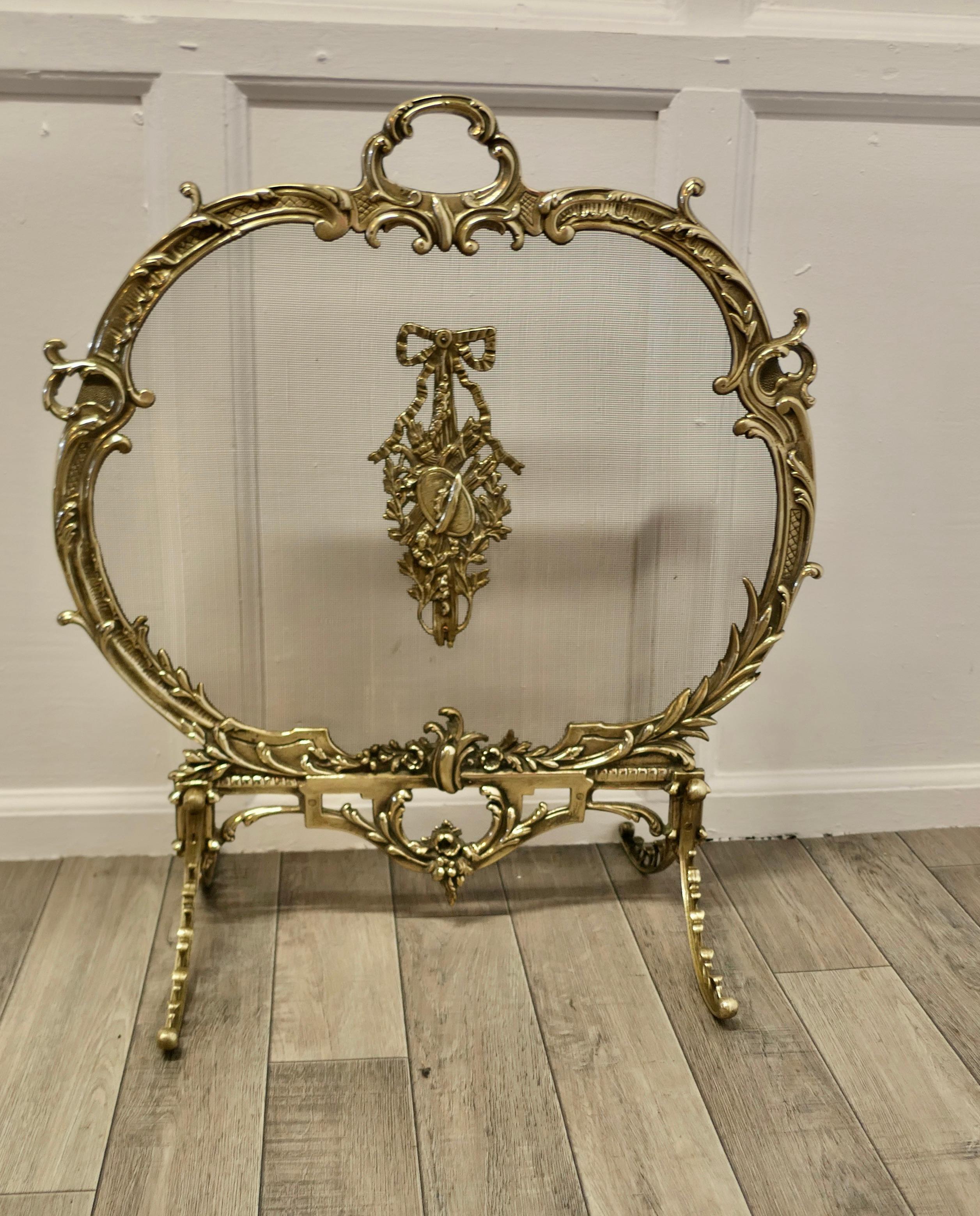 A Superb French Brass Rococo Fire Guard, Screen

The Fire guard is a superb quality piece, it is Oval in shape with a carrying handle to the top. The frame is very decorative ormolu and it has a fine mesh screen incorporated to stop any damage to