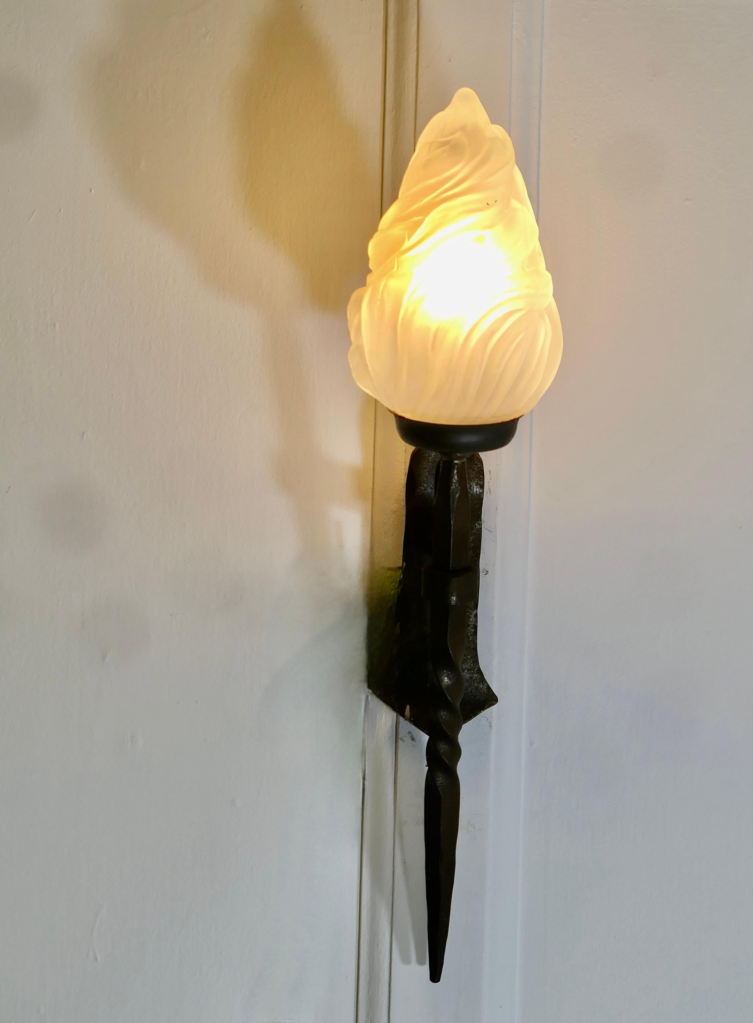 Una splendida lampada da parete d'ingresso gotica francese in ferro 

Una bellissima applique francese in ferro con paralume a fiamma in vetro, la luce è leggermente inclinata e valorizzerebbe l'ingresso di qualsiasi porta in stile gotico o