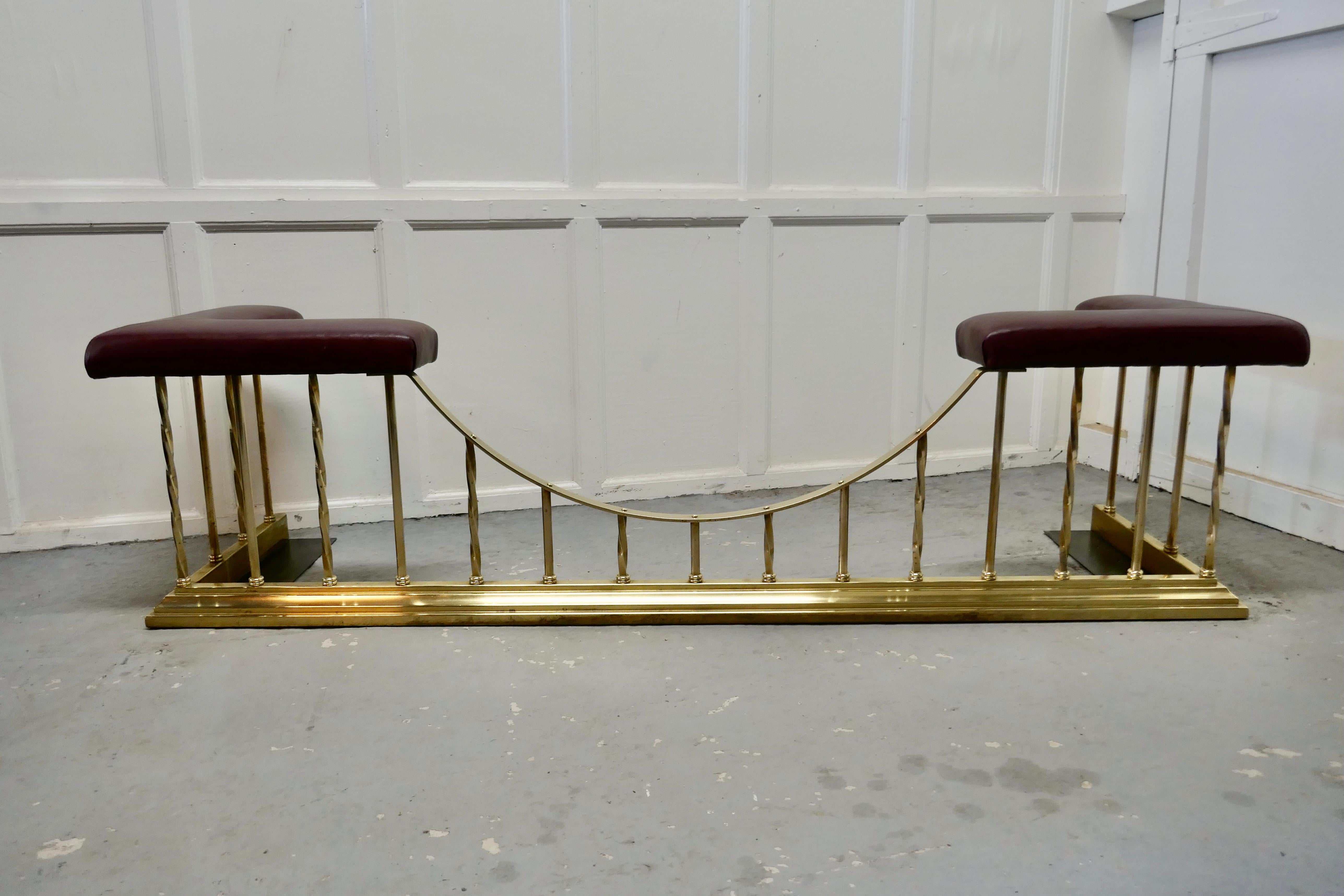 A superb large brass and leather club fender.

This is an elegant piece of country House Furniture, the brass fender has newly upholstered seats, this is soft leather in a rich red 
The brass rods are alternately in a decorative barley twist
The