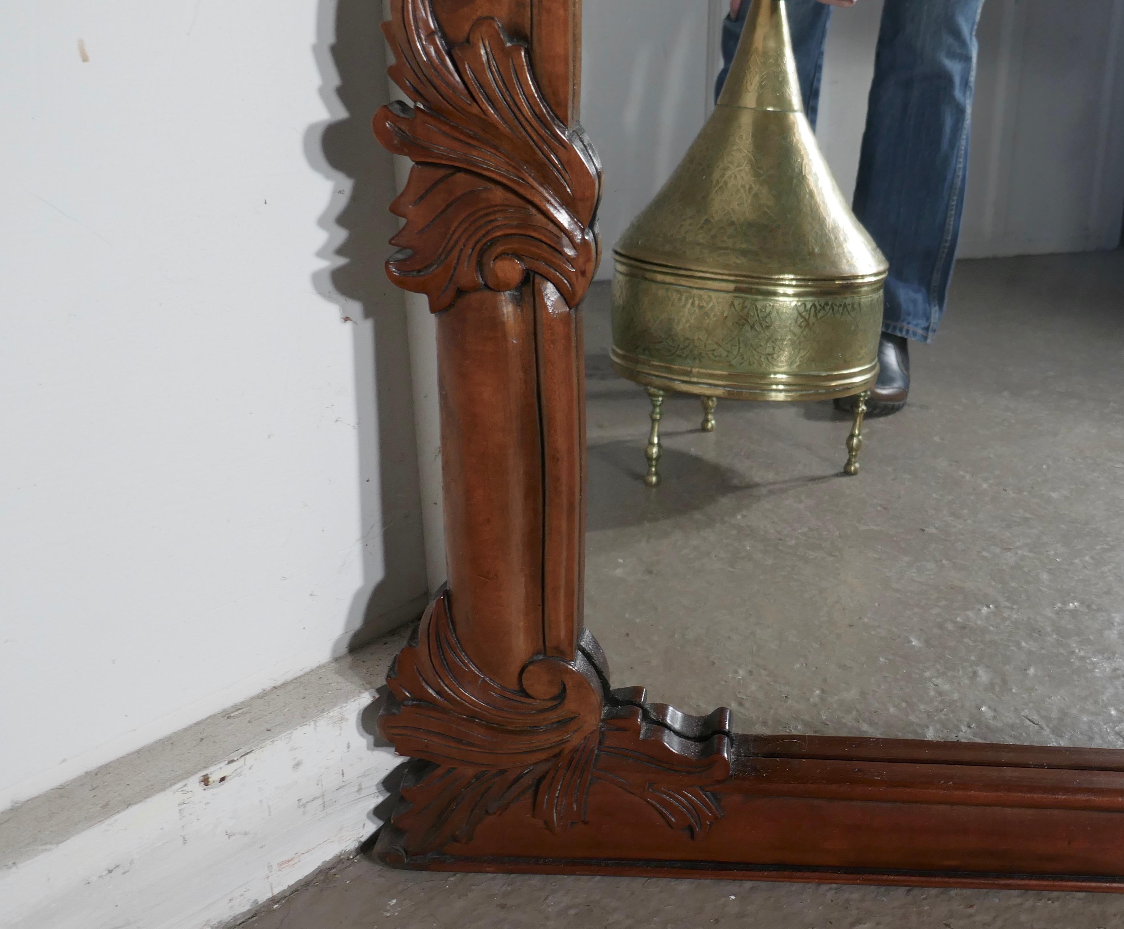 A superb large carved mahogany overmantel mirror

This is a striking piece it has a rectangular shape carved with entwined leaves and swags carved on both sides and over the top
The mirror is in lovely red Mahogany and would set off the