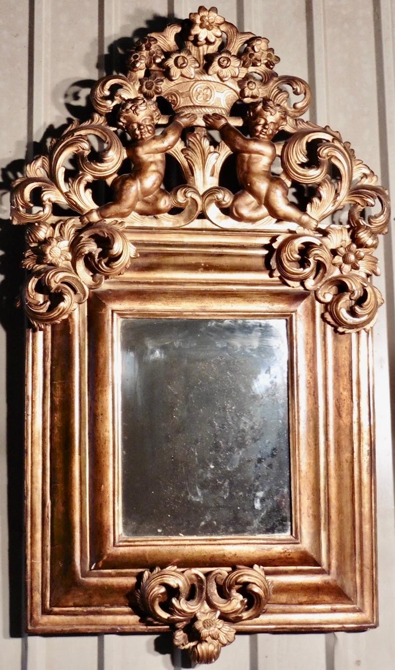 A Superb Large Early 19th Century Carved Gilt Mirror

 This is the most impressive large carved gilt mirror, the glass is set in a deep moulded frame which is crowned with exquisite carvings of cherubs holding a basket of flowers, the flower theme