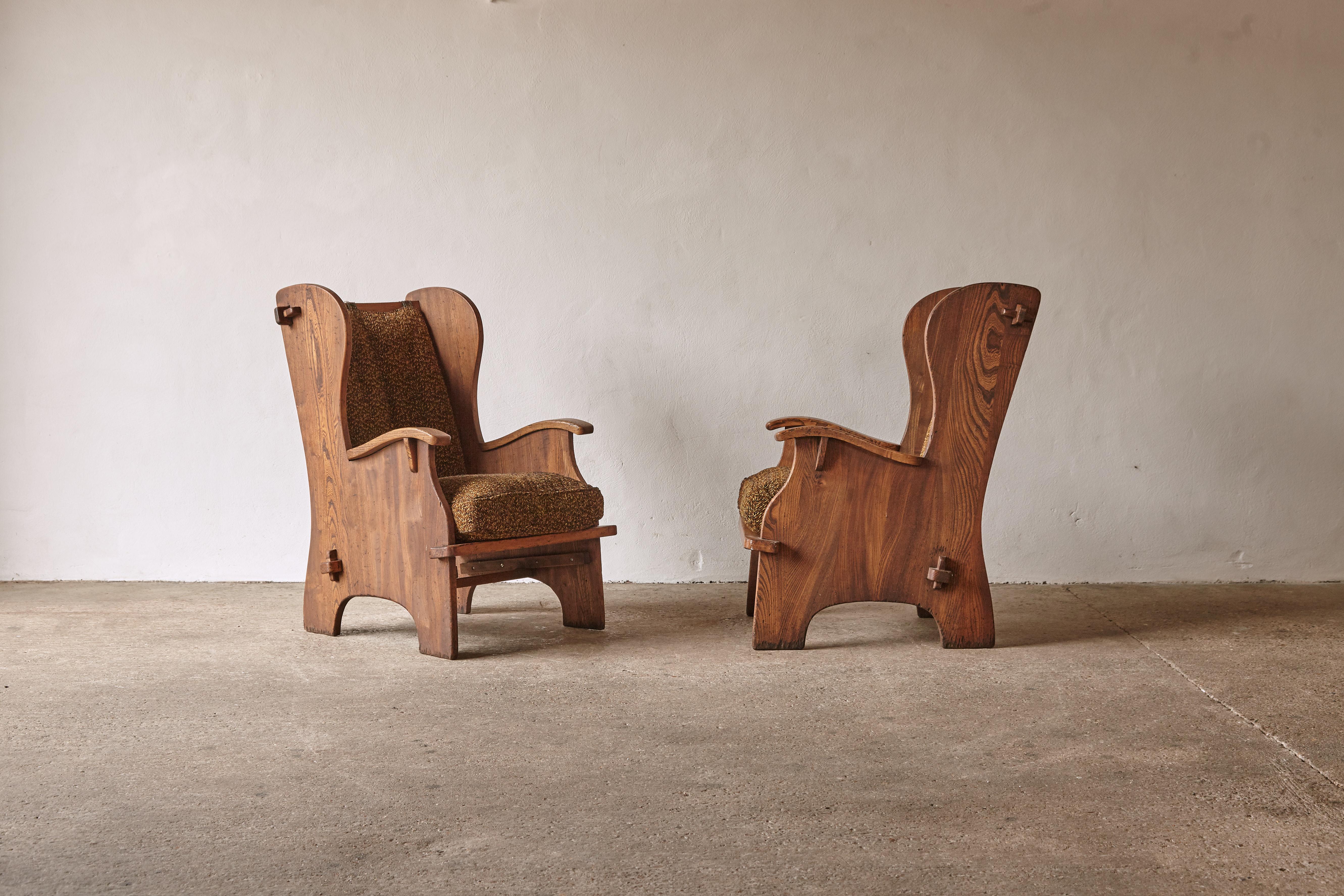 A super pair of English armchairs from the 1930s reminicent of Axel Einar Hjorth's Lovo chair. The chairs are sold in original condition with a wonderful patina to the wood. They would benefit from new fabric as there are some small stains and