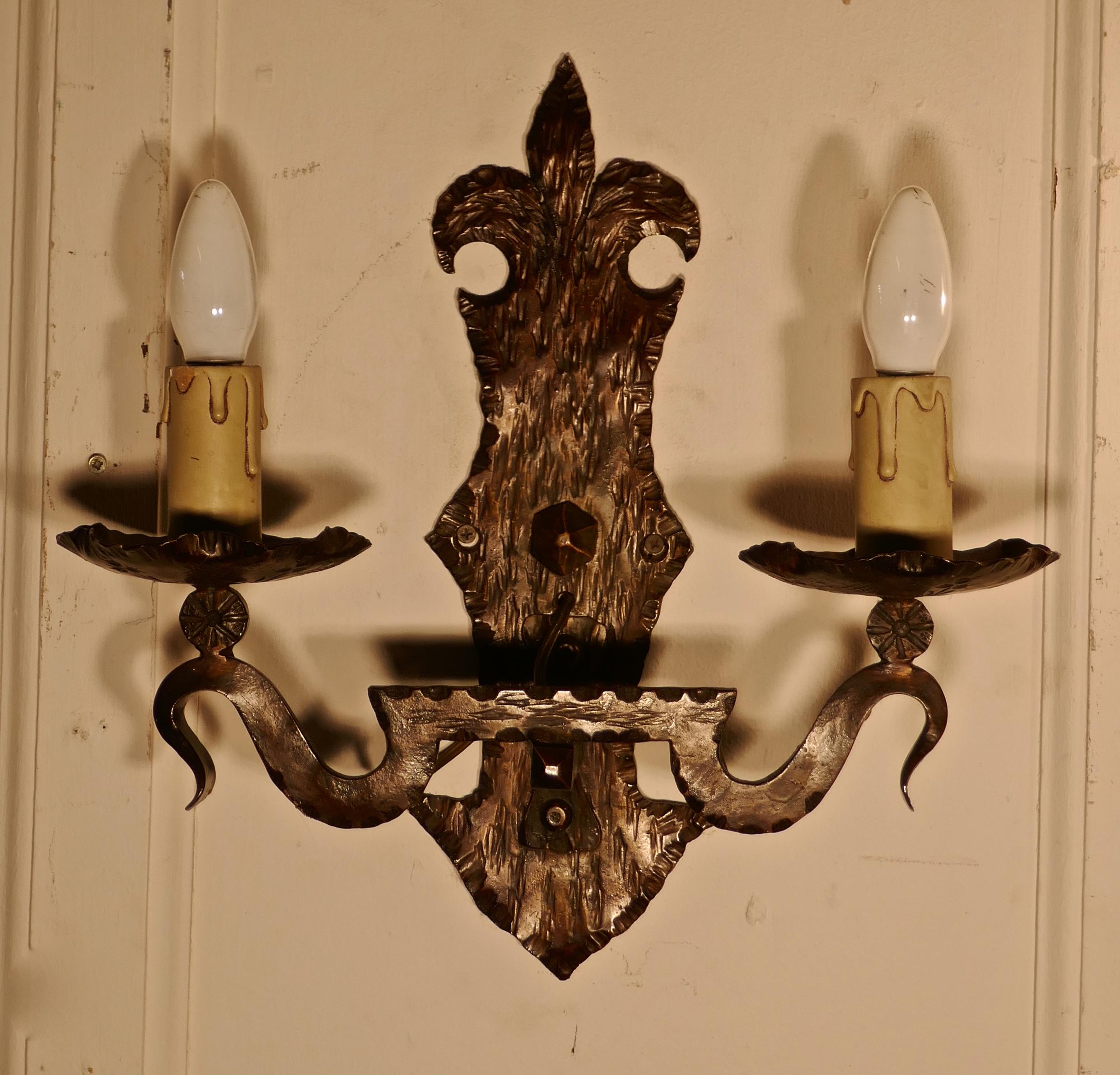 A superb pair of French Arts & Crafts Gothic iron wall lights. 

A very handsome pair of Heavy French Blacksmith made wall lights, the backplates are in the Bretton Arts & Crafts style and they each supports 2 sconces, the beaten iron has slight