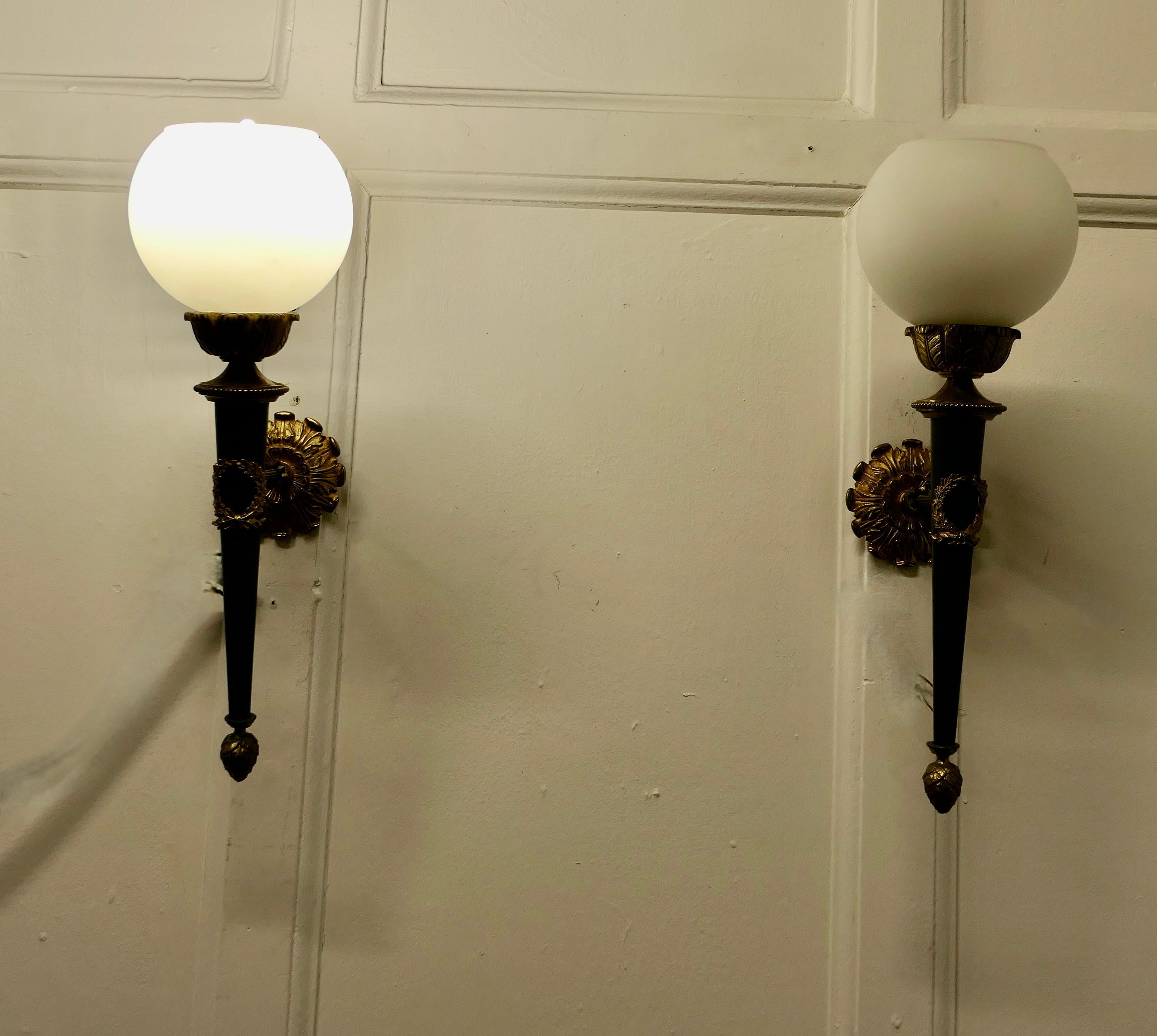 A Superb pair of French Ormolu Wall Lights

A very handsome pair of French wall lights, the lights are designed like an Olympian torch with an opaline glass shade and the brackets are set with ormolu 
The lights are in good and working condition,