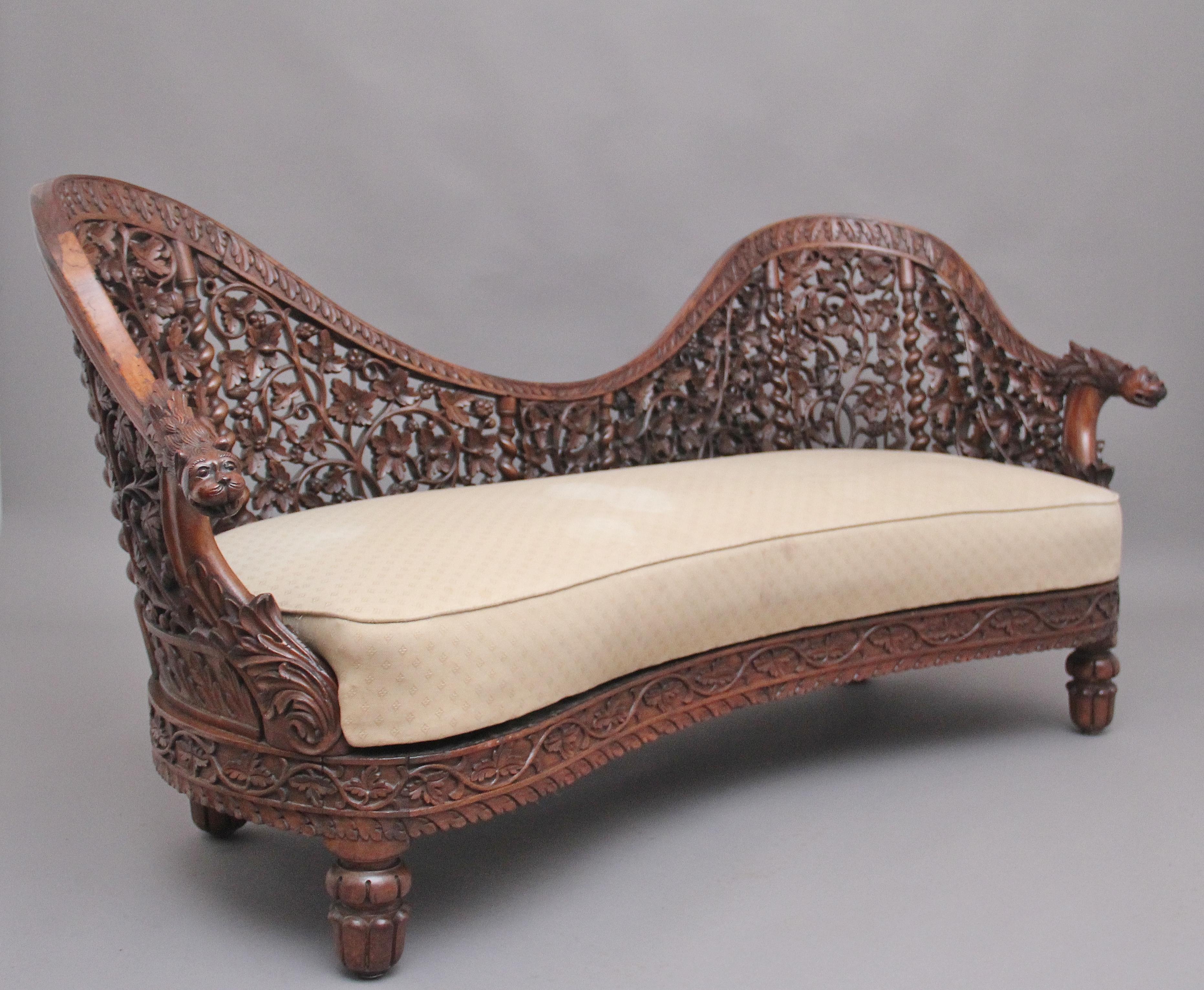 A superb quality 19th century Anglo-Indian carved sofa, the shaped back profusely carved with various foliage, carved twist supports, the outer frame incorporating decorative carved leaves which terminates with mythical figure heads at each side,