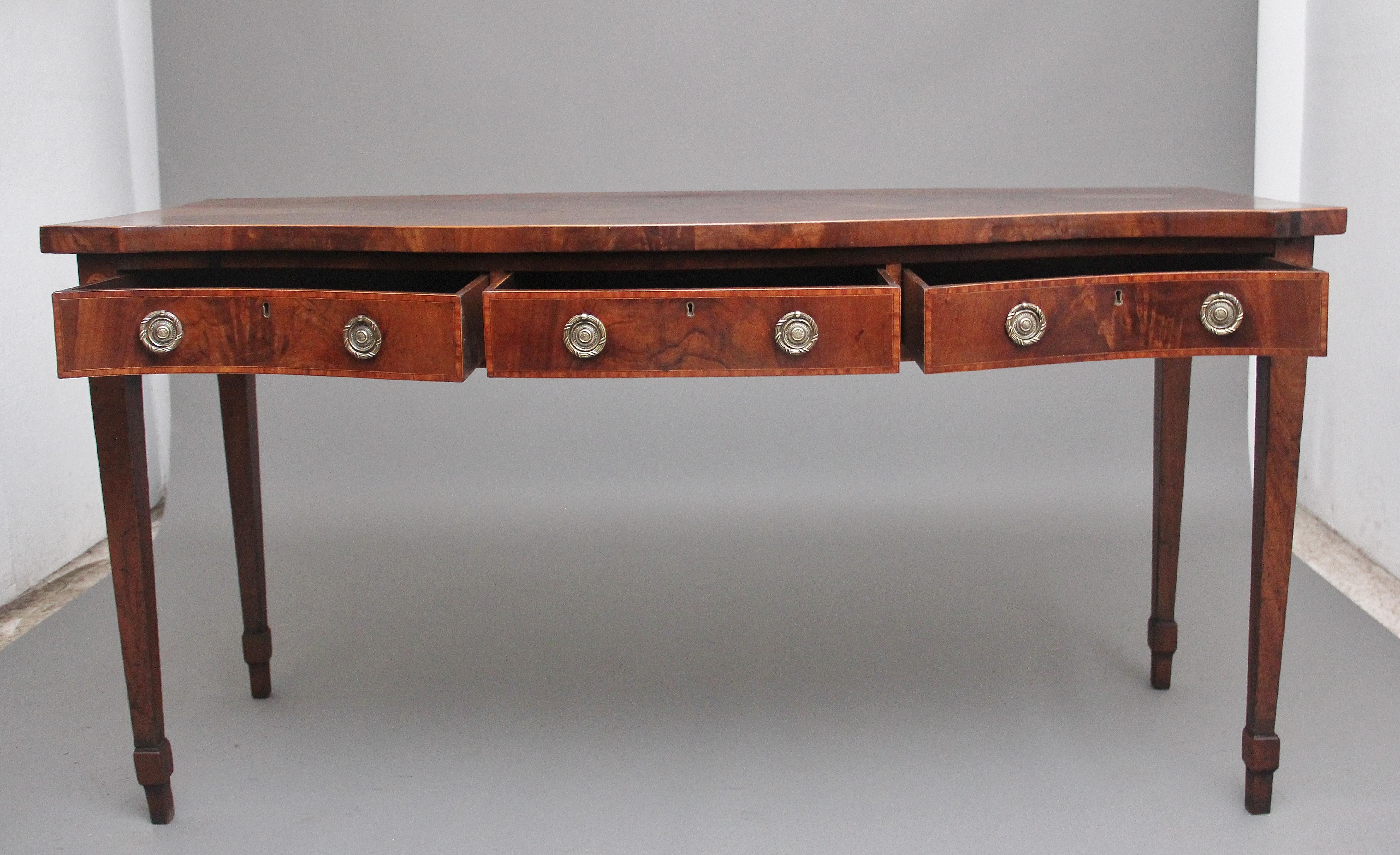 A superb quality early 19th century mahogany serpentine serving table, having a wonderfully figured shaped top with boxwood stringing along the edge above three drawers with the original brass ring handles, crossbanding on the drawer fronts, having
