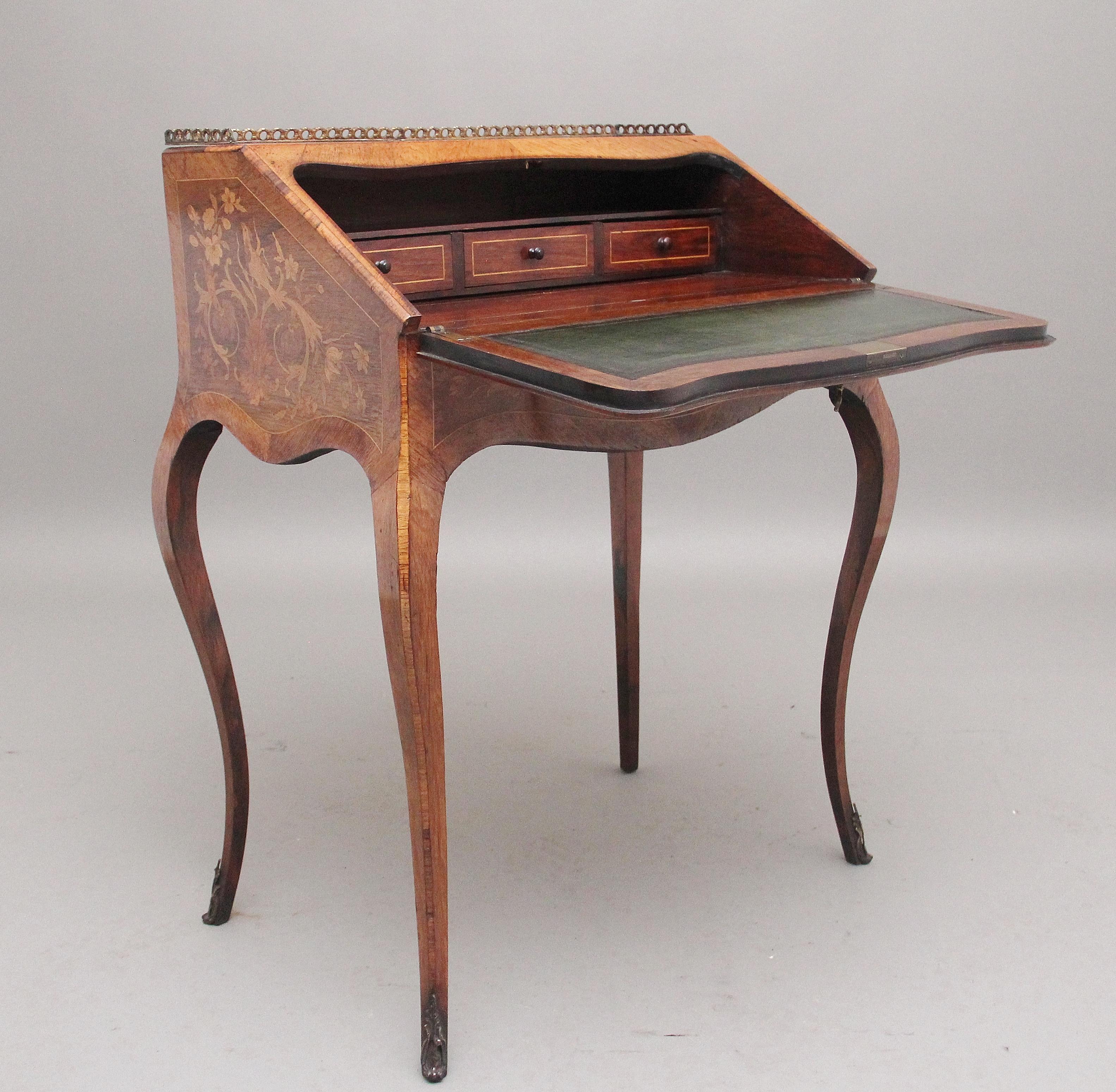 A superb quality freestanding 19th century Kingwood and marquetry inlaid bureau, having a brass gallery running along the back and sides of the top, the shaped bureau fall below opening to reveal a green leather writing surface with blind and gilt