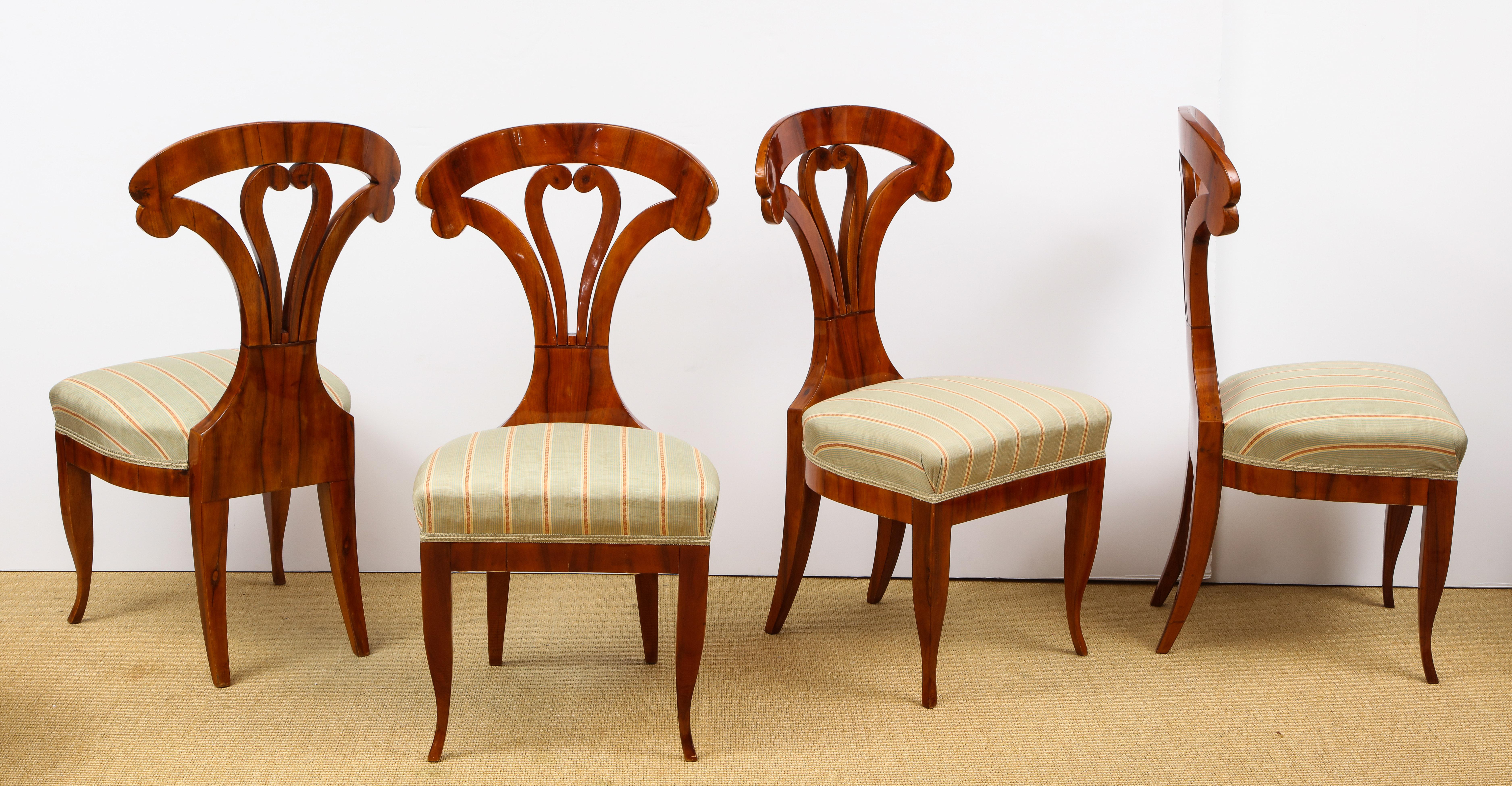 Each walnut veneered chair with intricately stylized back over an upholstered seat supported by a similarly veneered rail and 4 stylized legs.
  