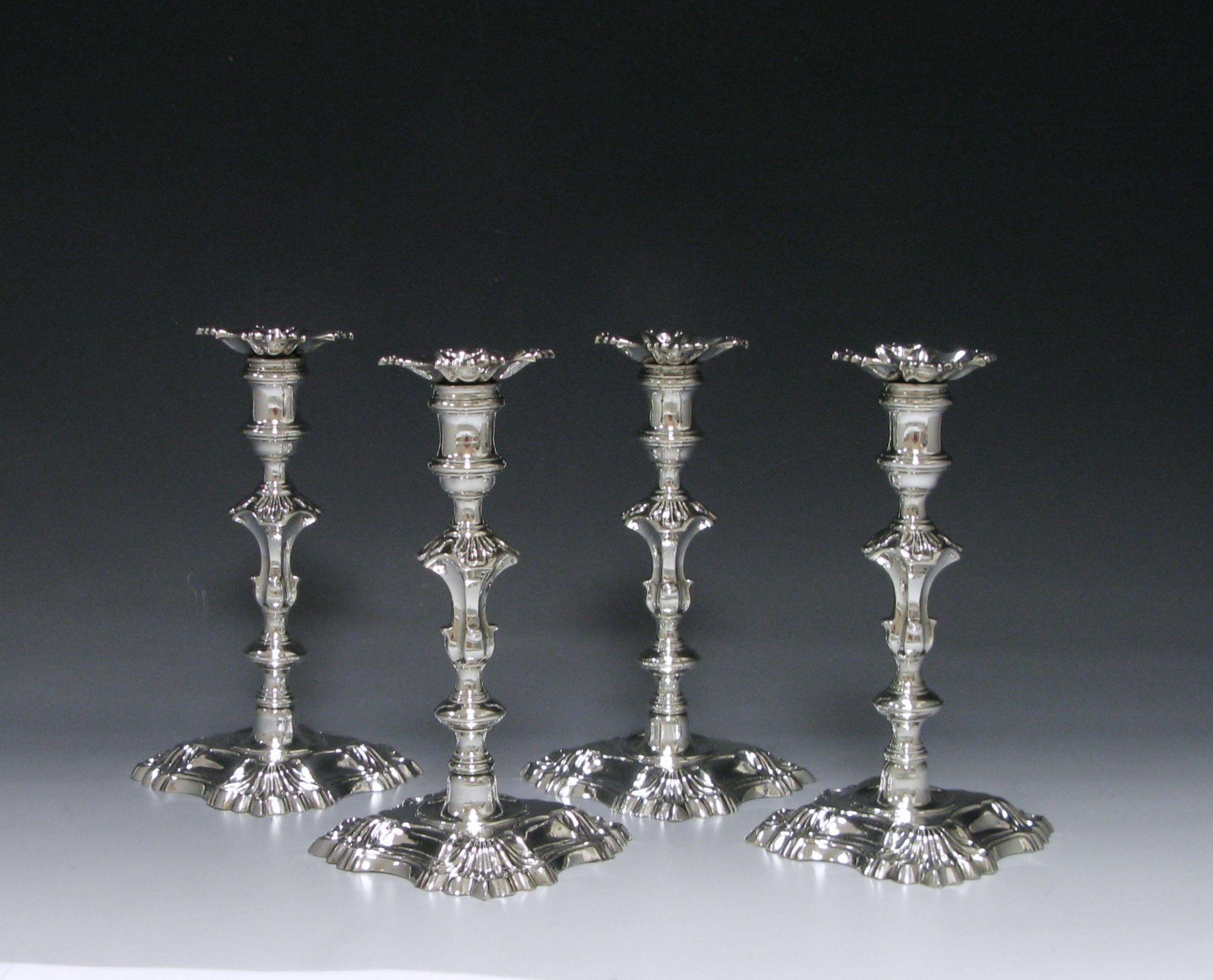 A superb set of George II antique silver cast candlesticks. The knopped baluster formed stems lead to reeded spool –shaped sconces tapering to acanthus embellished shoulders. The conventional formed nozzles are detachable, lobed shaped and
