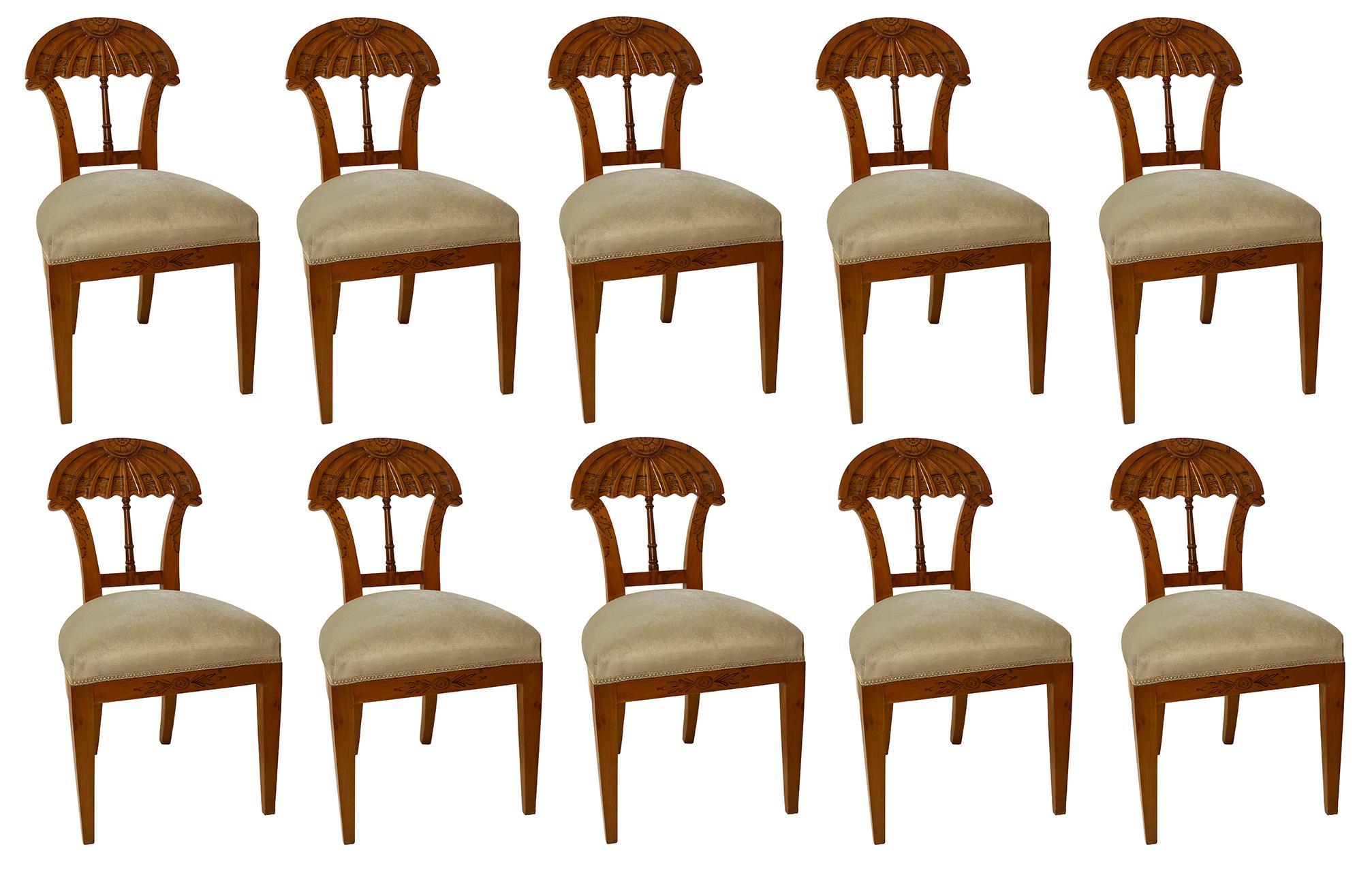 A rare set of 10 Biedermeier fruitwood and penwork dining chairs, the backs the arched fluted area with intricate penwork, above two bird head stands with penwork, supported by a balustrade stretcher, the frieze decorated with additional penwork,