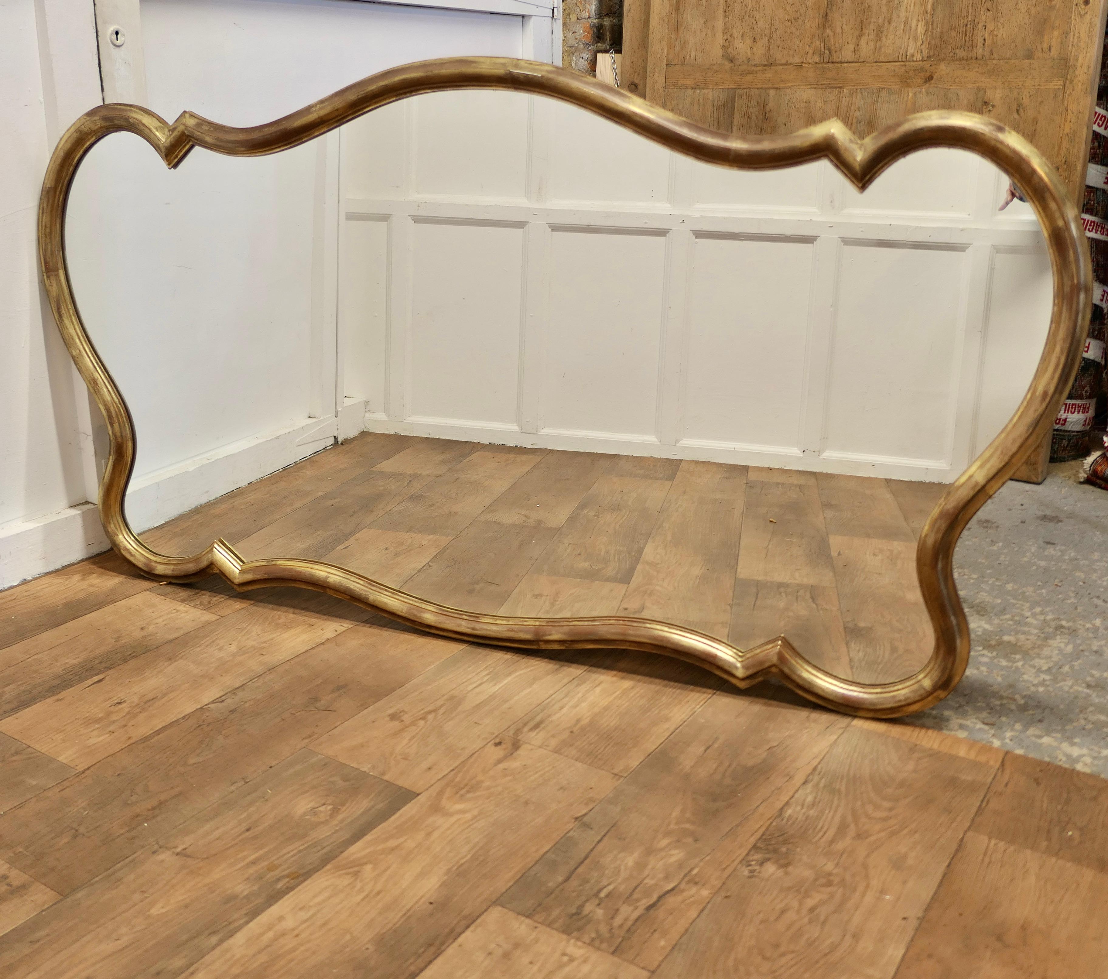 A Superb Very Large Italian Gilt Scallop Shaped Mirror

This is a very Striking piece it has a superb scrolling shape with lots of curves and rounded corners 
The mirror is a lovely aged rich gold colour and would set off the decoration of any room