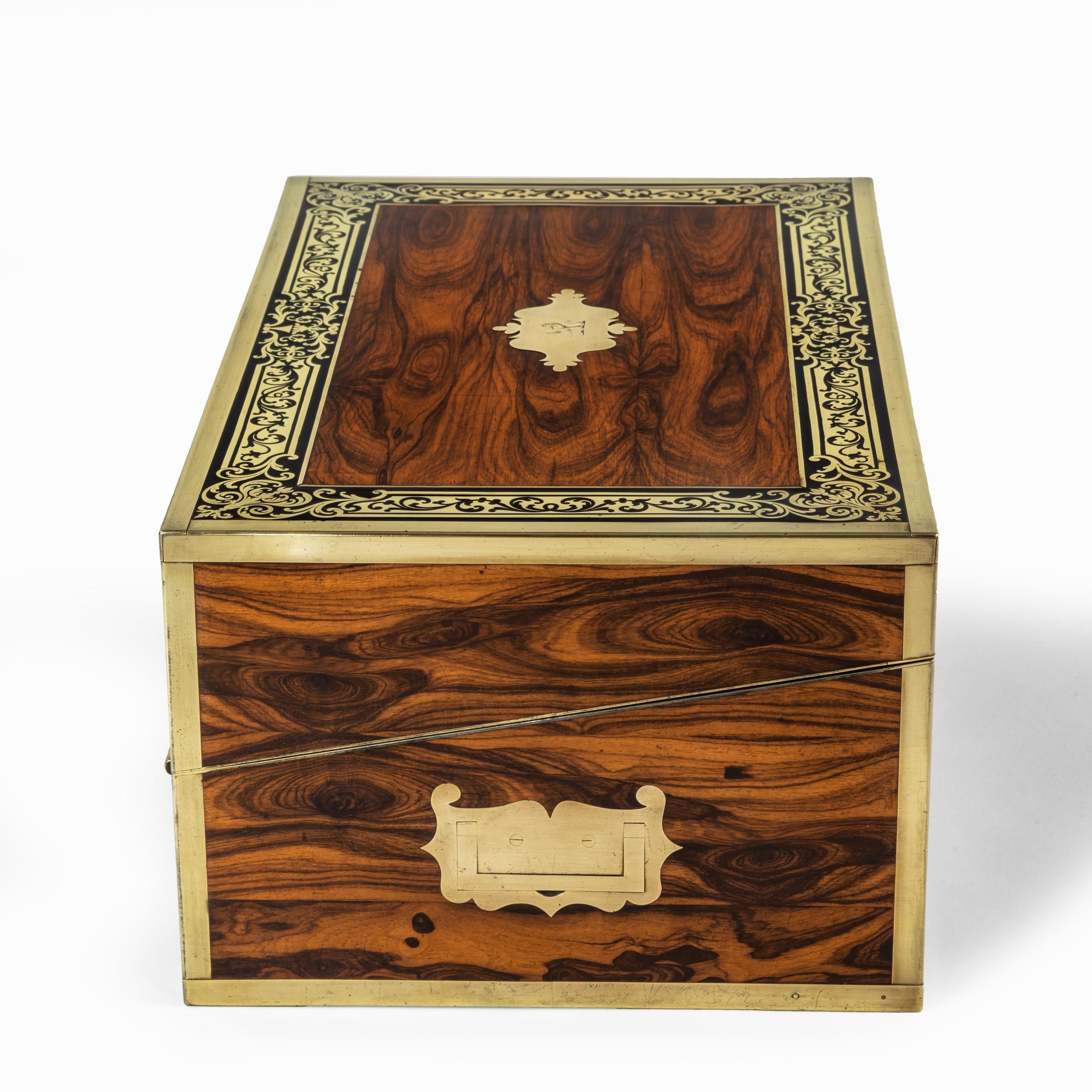 A superb William IV brass-inlaid kingwood writing box by Edwards, of typical rectangular form opening at an angle to reveal a pen tray flanked by covered and open compartments above a writing slope created by two hinged panels inset with tooled
