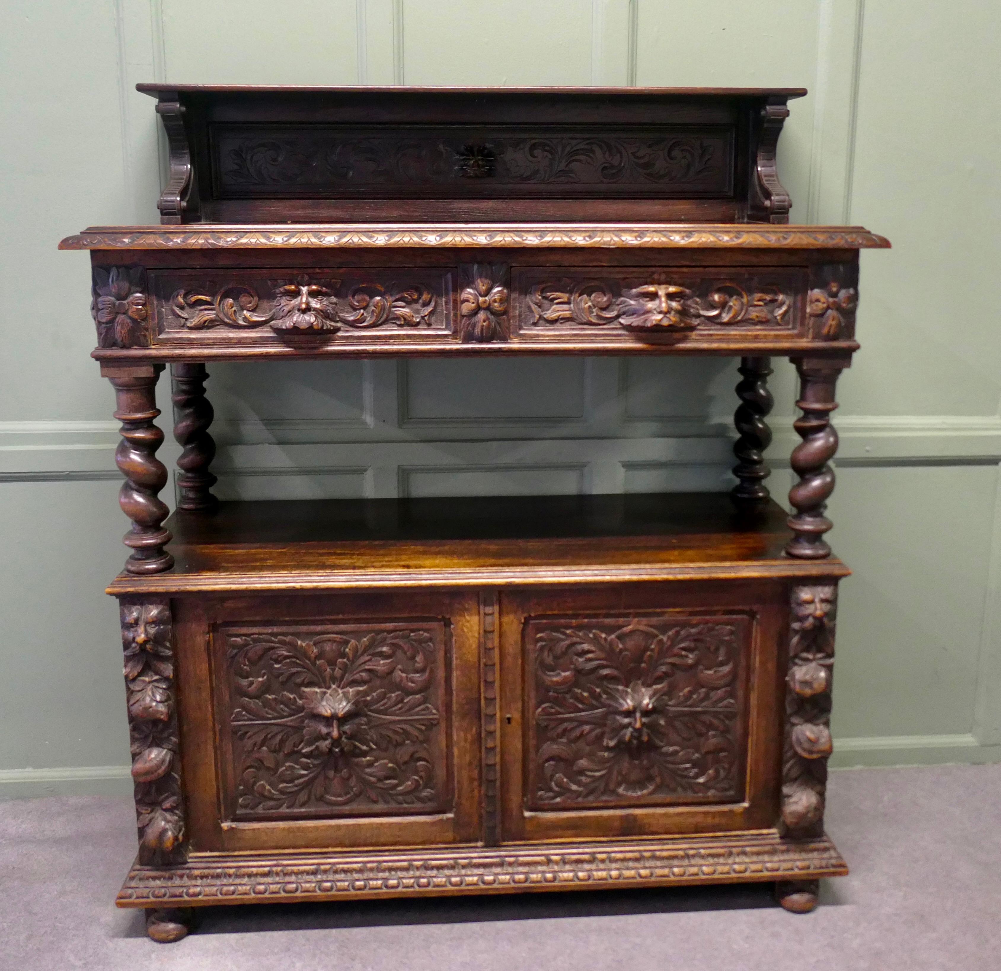 A Superbly Carved Green Man Oak Side Board or Buffet 

The buffet is similar to a court cupboard and has a counter top with a carved edge beneath a higher plate shelf, there are two drawers set into this which have heavily carved fronts each one