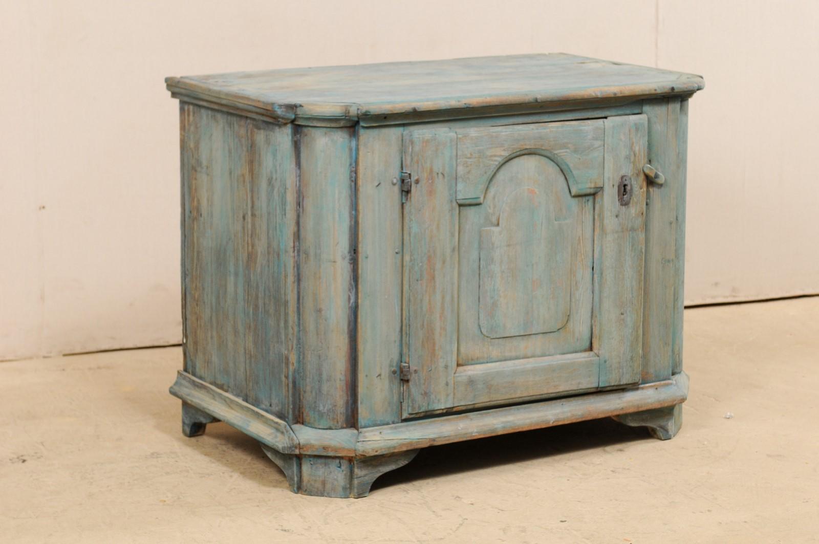 A Swedish painted wood cabinet from the 18th century. This antique storage cabinet from Sweden has an overall rectangular shaped top, which overhangs a case with a single door.  The doors are flanked with rounded halved column carved front side