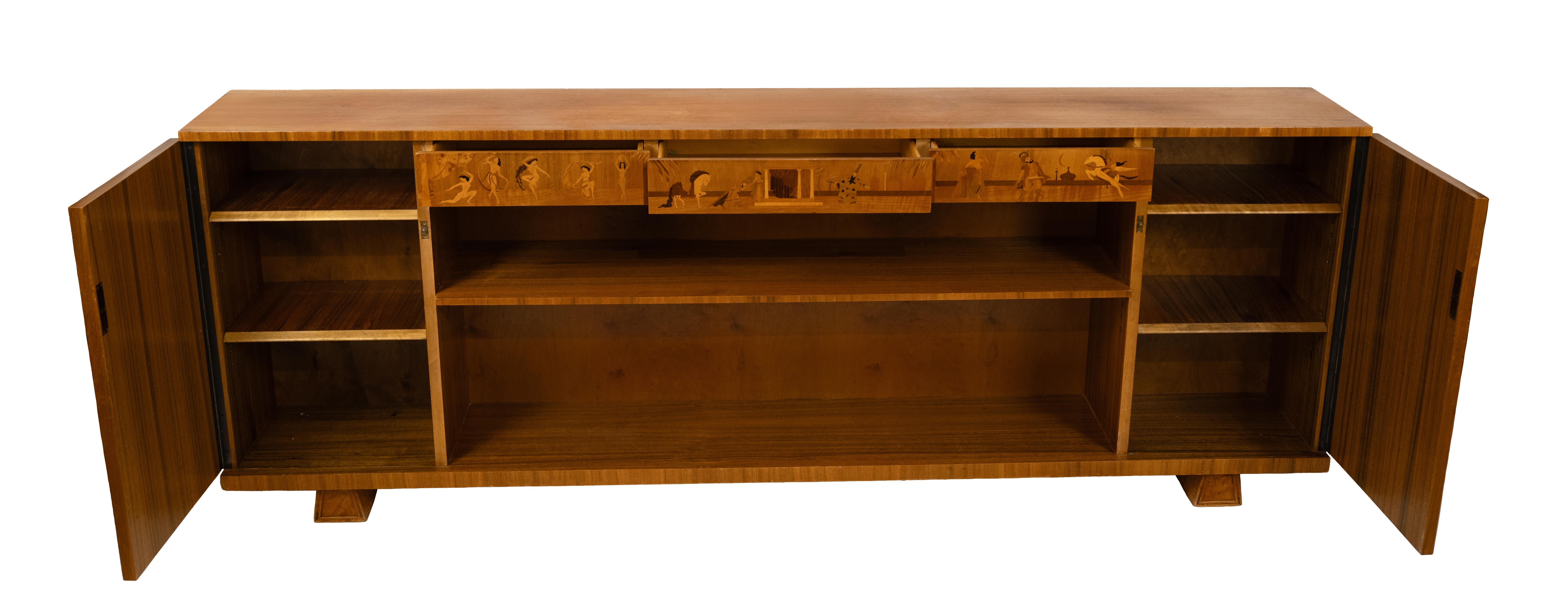 Mobiletto basso svedese in stile Art Déco con ripiani centrali e armadietti laterali in palissandro molto scolpito. Il grembiule superiore è intarsiato con scene da Mille e una notte e contiene cassetti portaoggetti. Realizzato da Mjölby Intarsia,