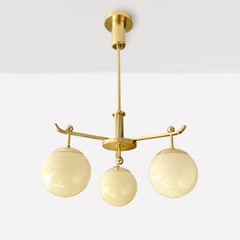 A Swedish Art Deco polished 3-arm brass chandelier with glass globes.
