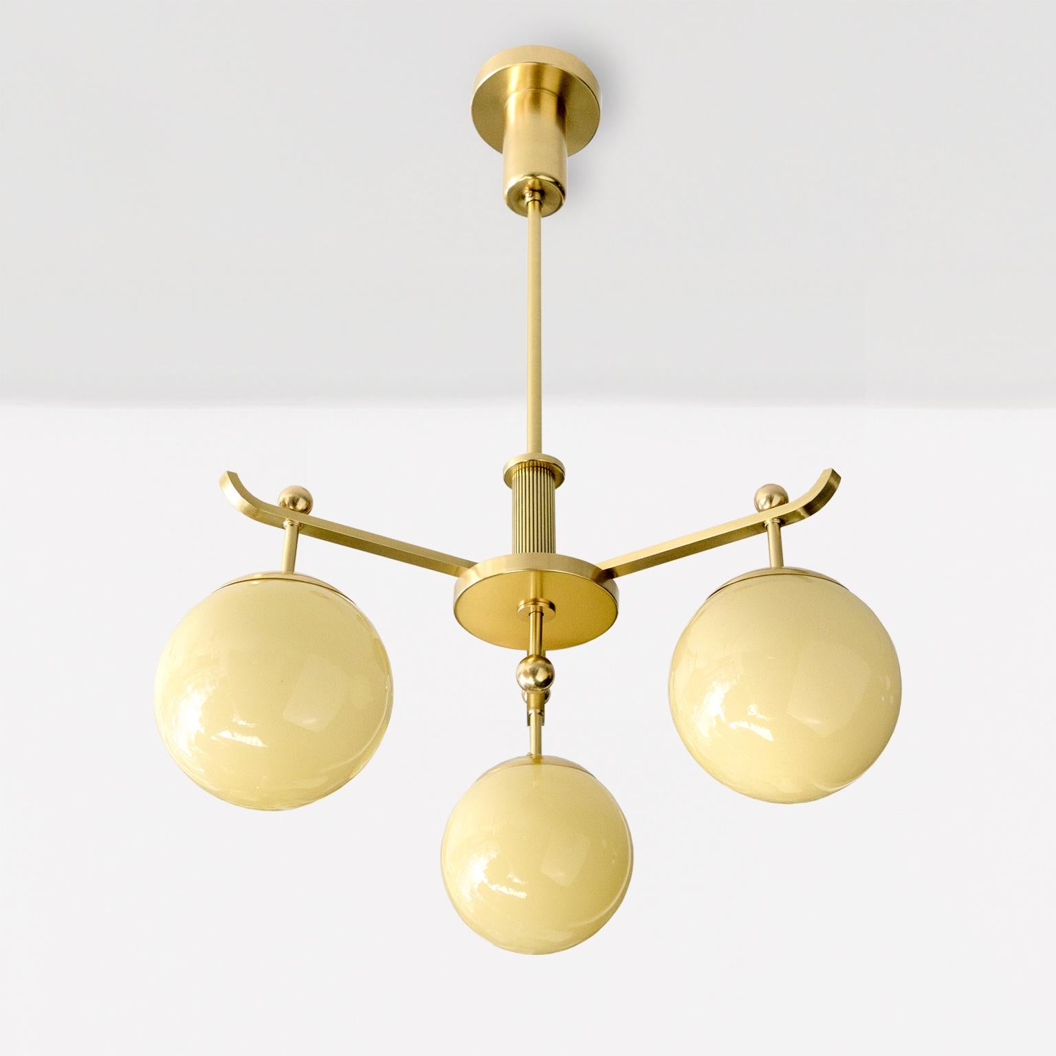 Scandinavian A Swedish Art Deco polished 3-arm brass chandelier with glass globes. For Sale