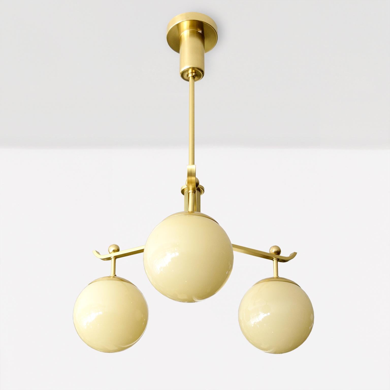 A Swedish Art Deco polished 3-arm brass chandelier with glass globes. In Good Condition For Sale In New York, NY