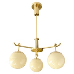 A Swedish Art Deco polished 3-arm brass chandelier with glass globes.