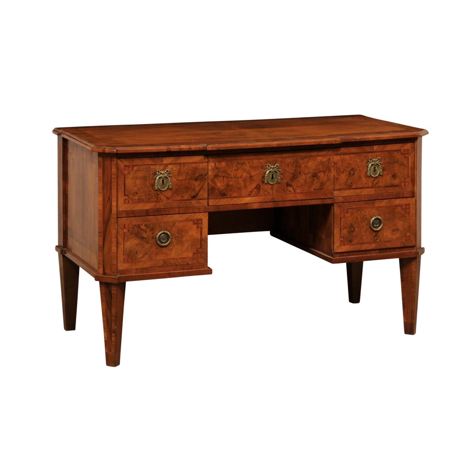 A Swedish Biedermeier birch veneered desk with drawers from the 19th century. This antique desk from Sweden, with it's beautiful birch wood grain veneer and decorative inlays, houses five-drawers (two stacked at either side and one at center),