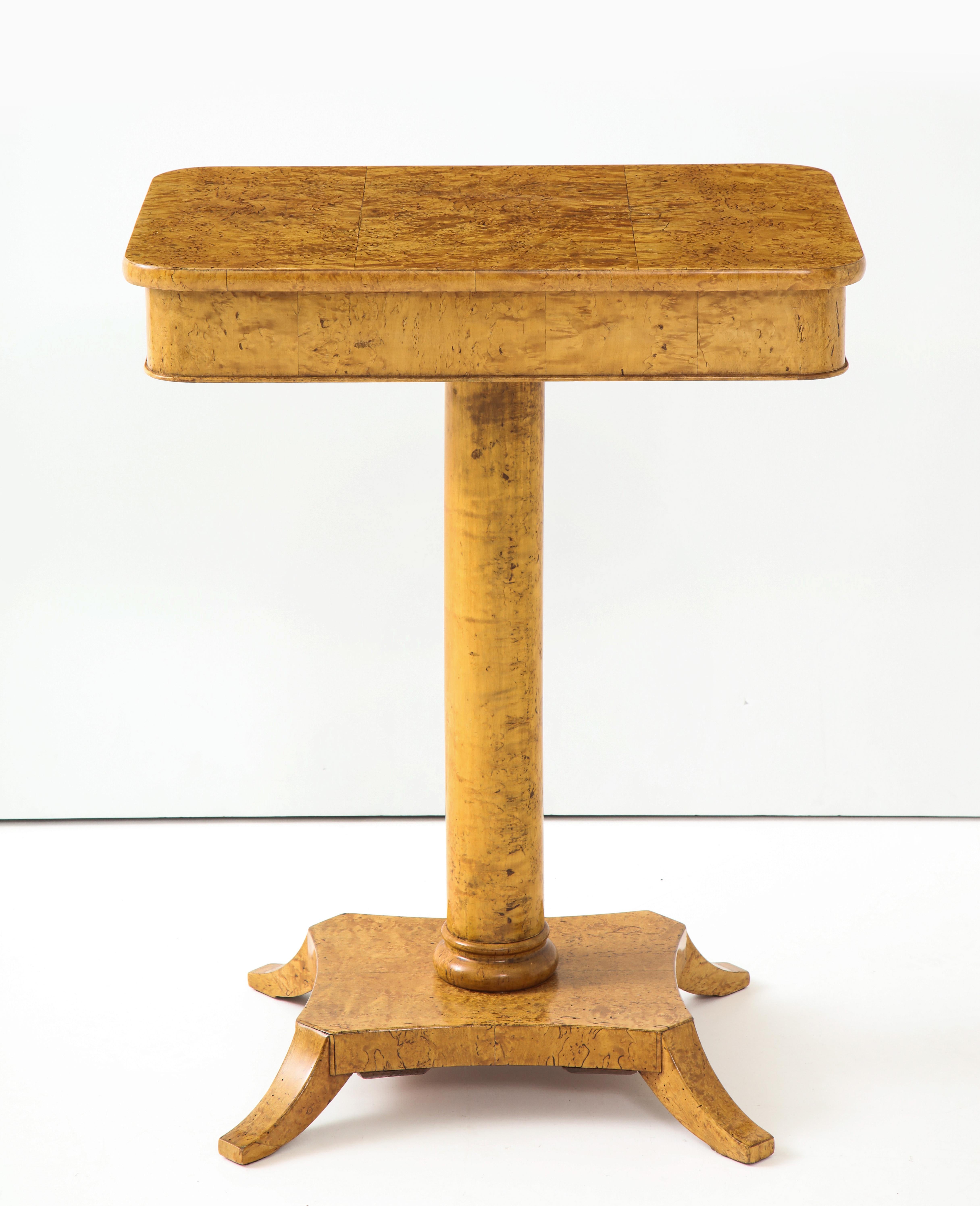 A Swedish Karl Johan birch root side table, mid-19th century, the rectangular top with rounded corners raised on a plain circular column stem ending with a plinth base and four short downswept feet. Beautiful example of birch root.

   