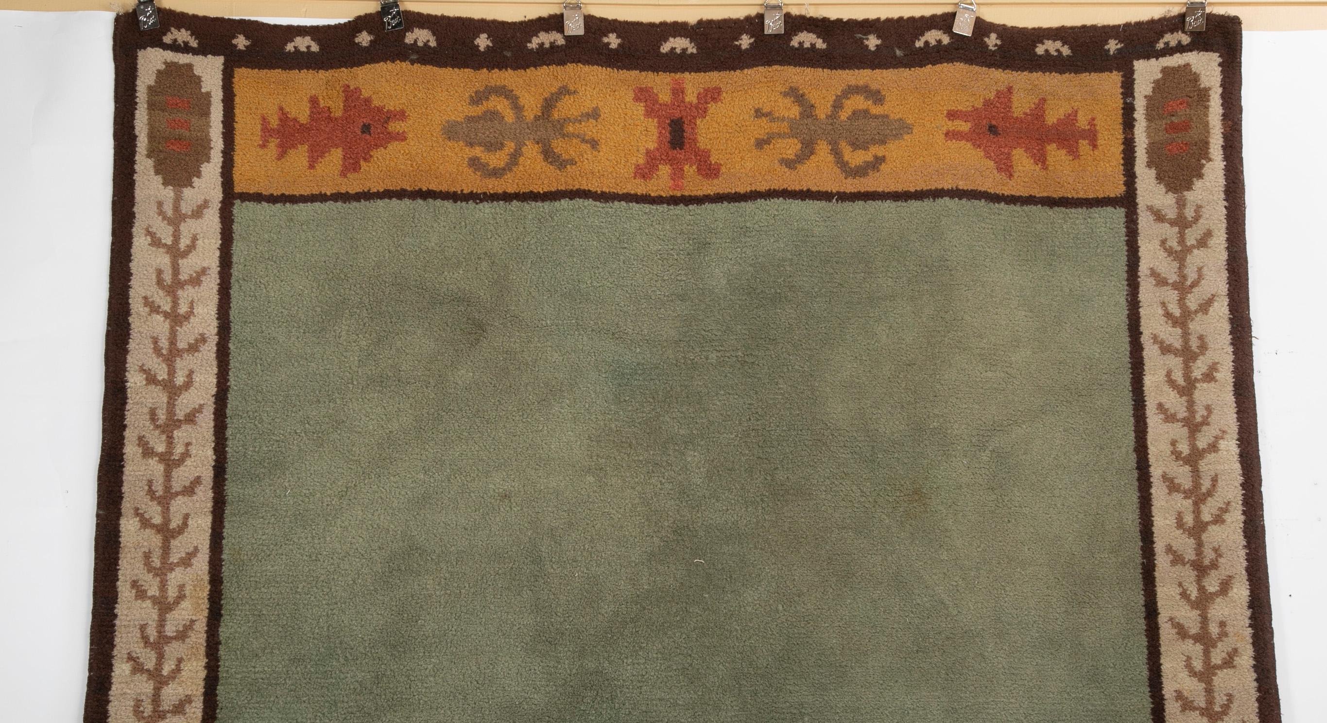 Ein Teppich aus der Mitte des Jahrhunderts mit einem Grund aus Seladon und einer Bordüre. Unterzeichnet und datiert. Schweden, 1933.