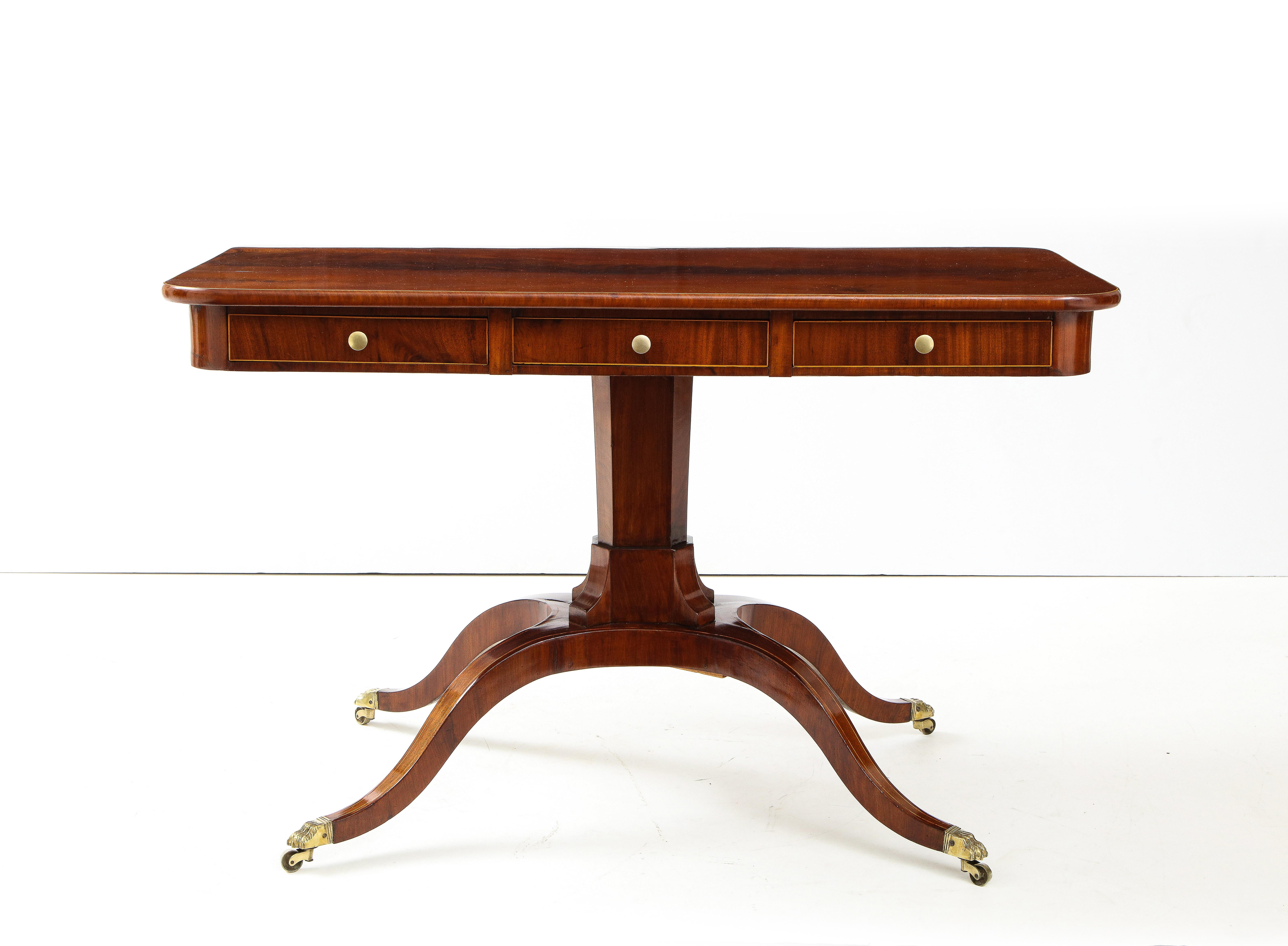 A Swedish Empire mahogany and fruitwood line inlaid sofa table, First Quarter 19th Century, the rectangular top with slightly rounded corners above a conforming frieze with three drawers, raised on an hexagonal stem with four downswept legs ending