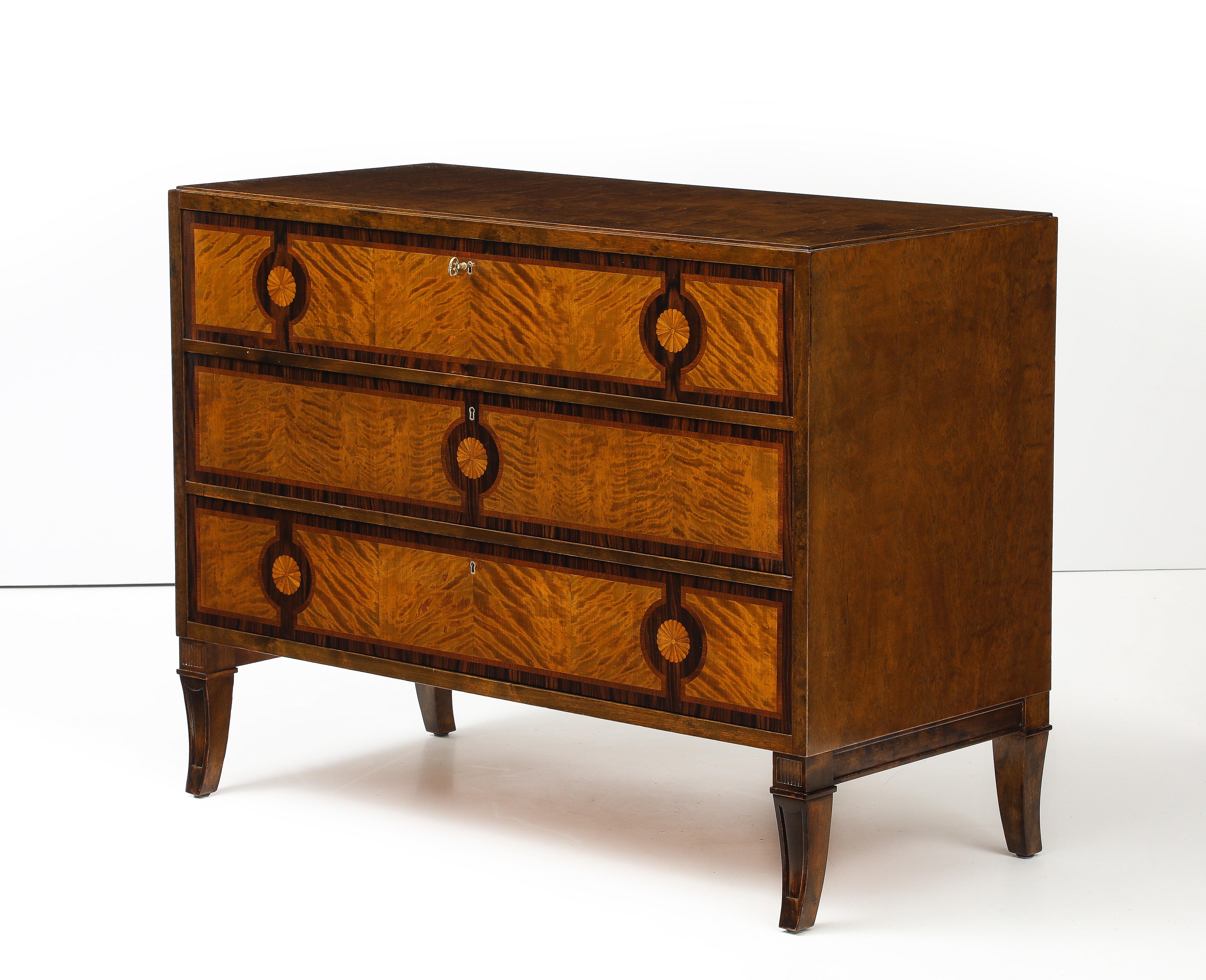 Schwedische Kommode mit Intarsien aus Grace-Birke und Palisander, CIRCA 1930er Jahre, wahrscheinlich für Nordiska Komapaniet hergestellt, rechteckige Platte über drei langen Schubladen mit Palisadenbändern. Umlaufende Fächerintarsien, umgeben von