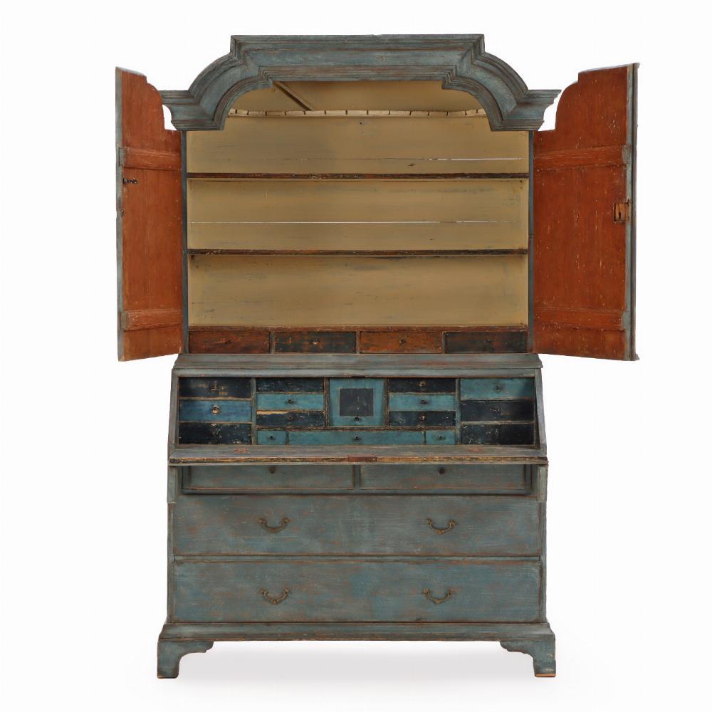 Questa bellissima scrivania inclinata è composta da due pezzi con una splendida superficie blu. Il  La cornice superiore ha un design rococò con due ante che si aprono per rivelare dei ripiani.  Il fronte inclinato si apre su un interno attrezzato