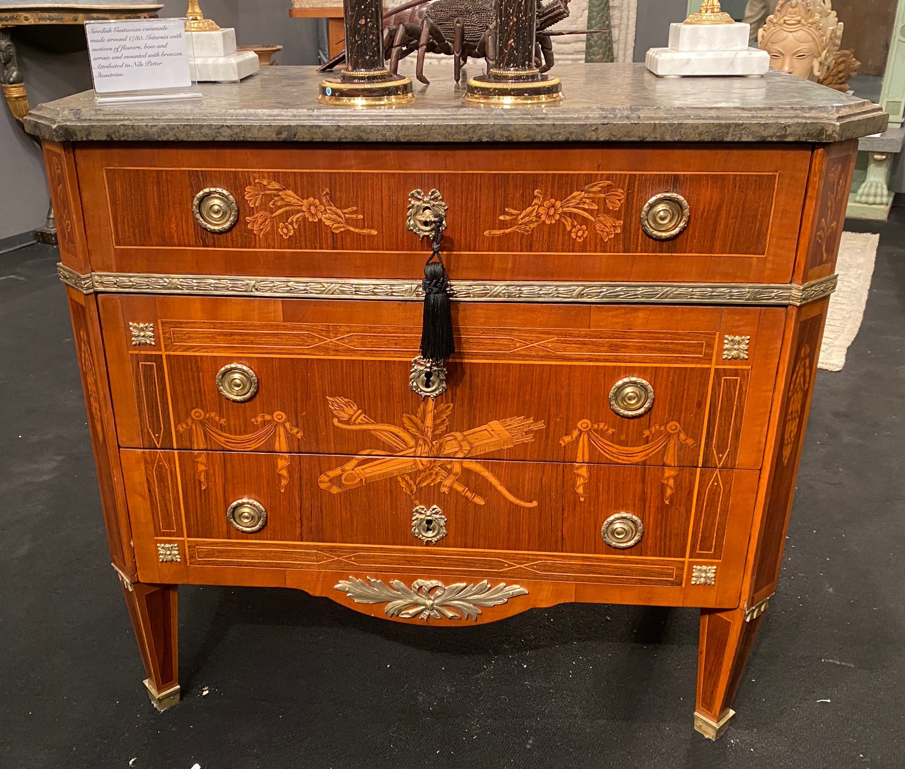 A Swedish Gustavian commode with a Swedish limestone top. Nice inlays in the shape of a bow and arrows, garlands and flowers. In Sweden most marble tops are made of limestone since they could be produced in the country. This top is unusually